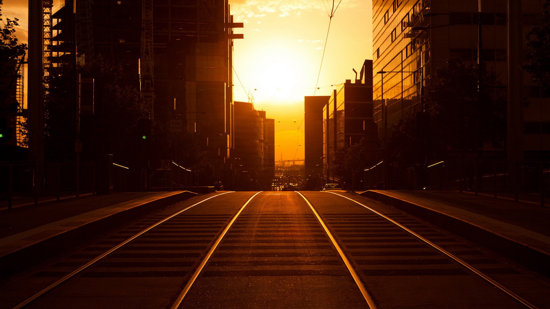 Tram tracks in a city at sunset HD Wallpaper