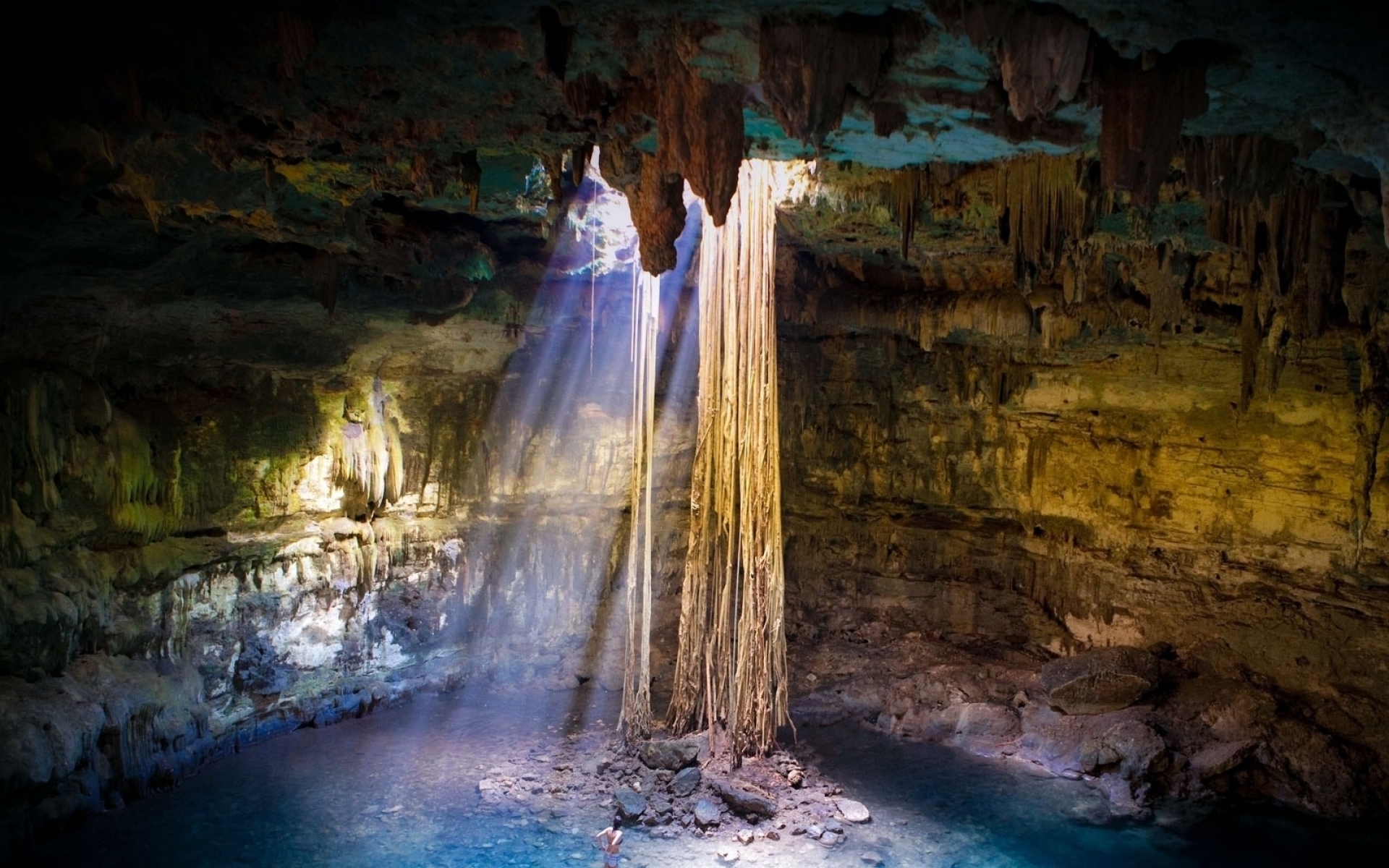 Cave with stalactites and sunbeams HD Wallpaper