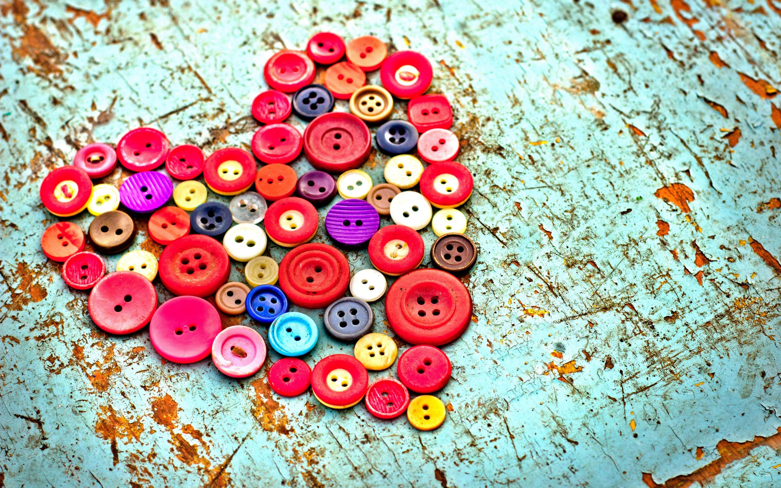 Heart shape made of colorful buttons on a distressed wooden surface HD Wallpaper