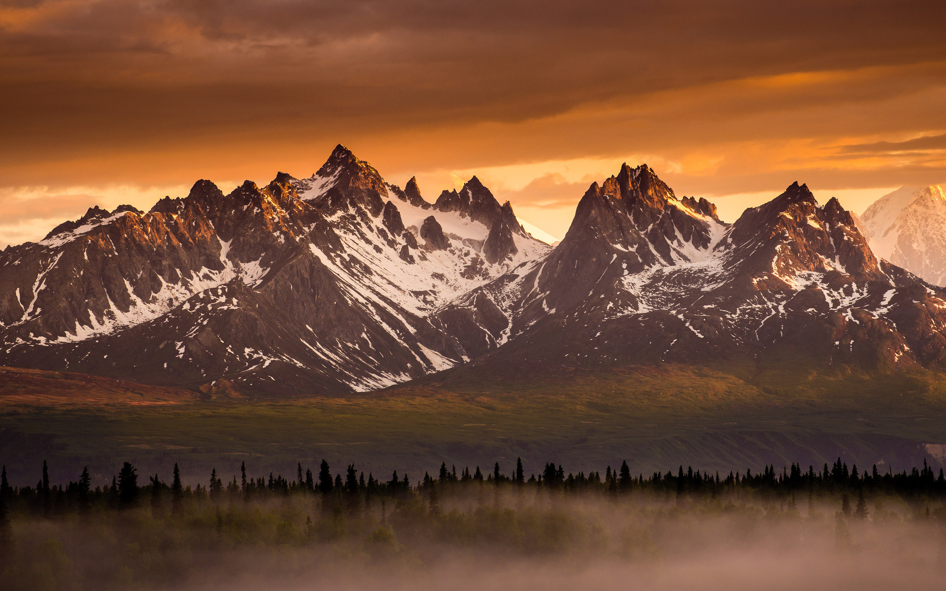 Snow-capped mountains at sunset with forest and fog HD Wallpaper