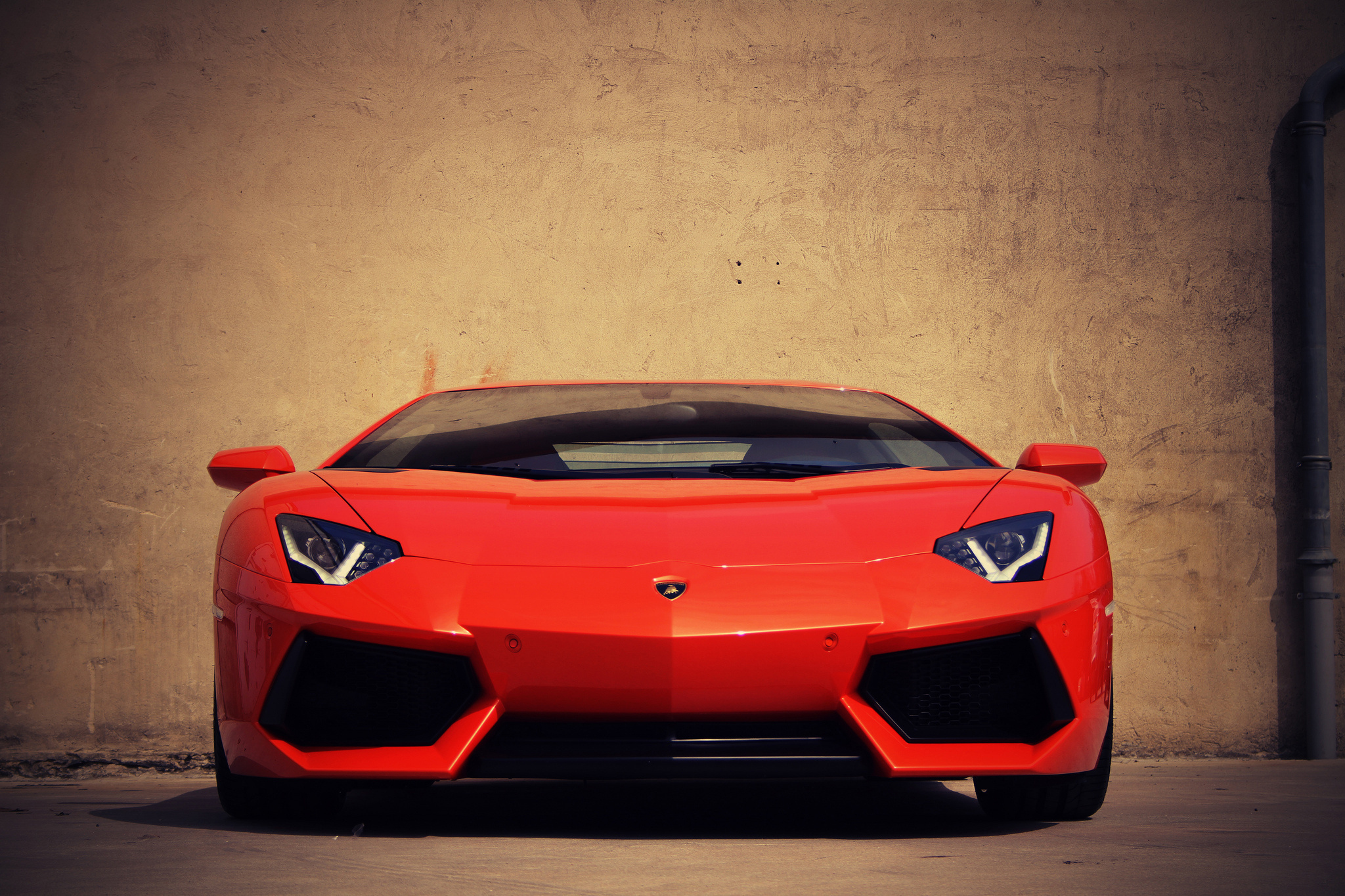 Orange Lamborghini Aventador parked against a wall HD Wallpaper