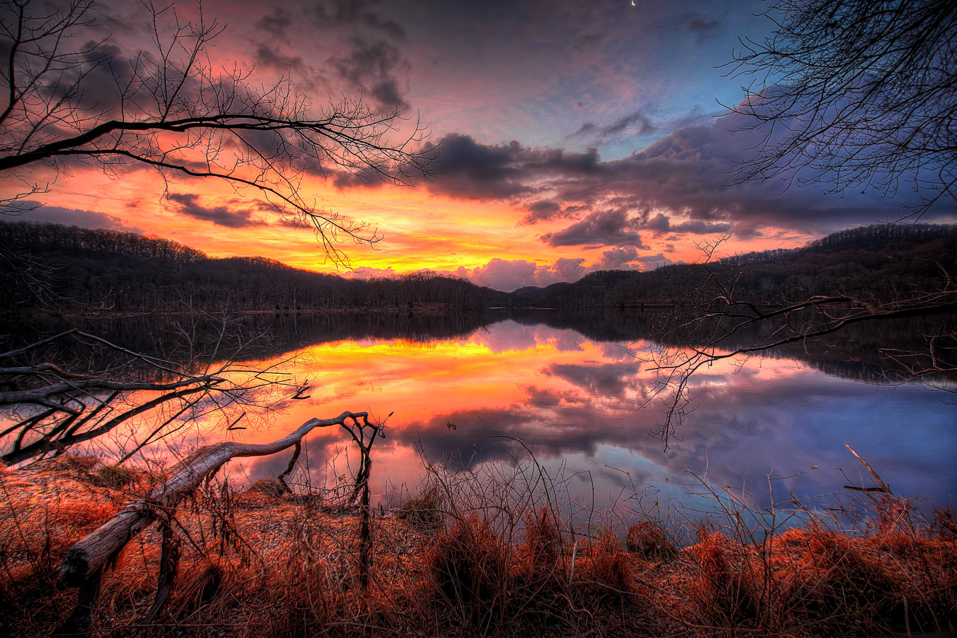 Sunset over a calm lake with dramatic clouds HD Wallpaper