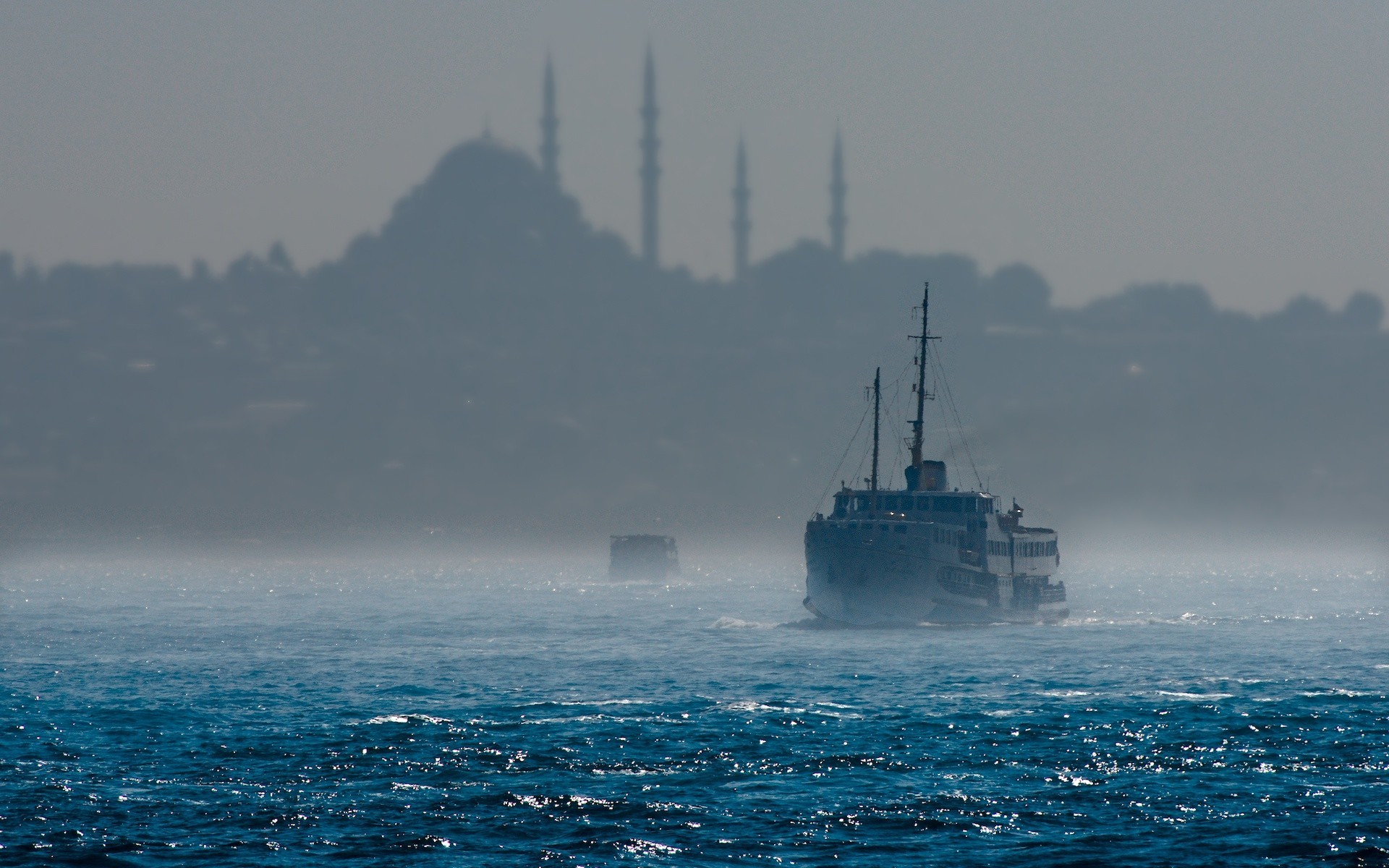 Ferry boat sailing on the sea with city skyline in background HD Wallpaper