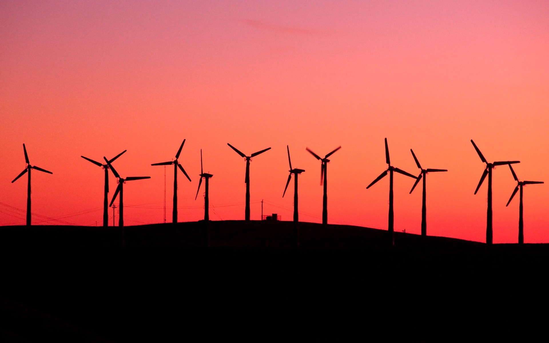 Wind turbines silhouetted against a sunset sky HD Wallpaper