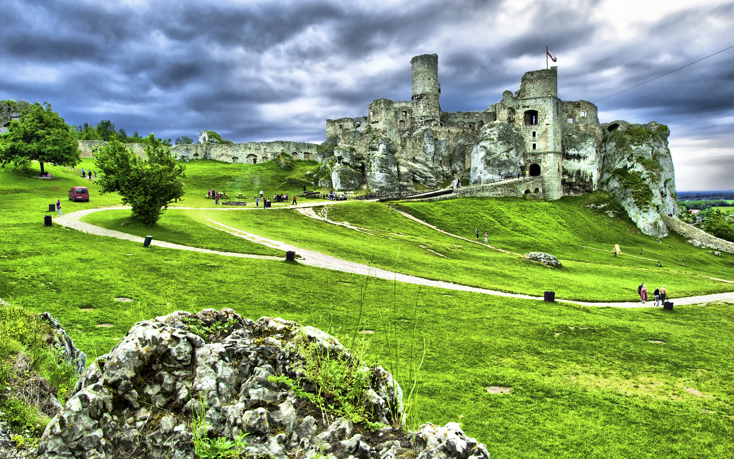 Castle ruins on a grassy hill under a cloudy sky HD Wallpaper