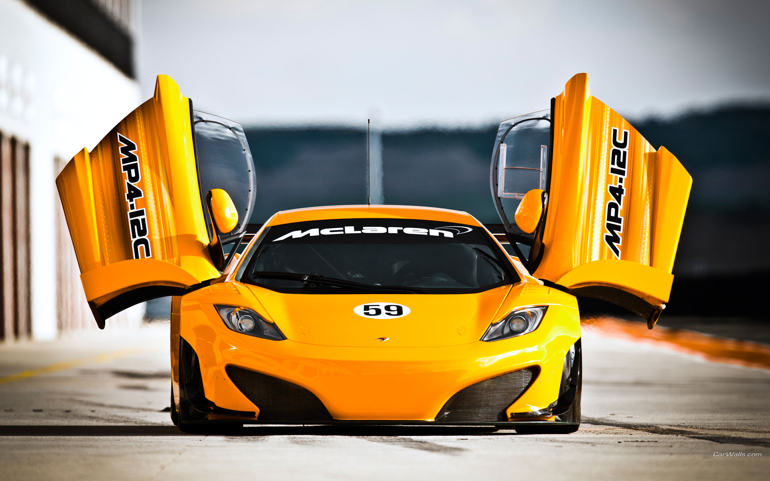 Orange McLaren MP4-12C race car with doors open HD Wallpaper