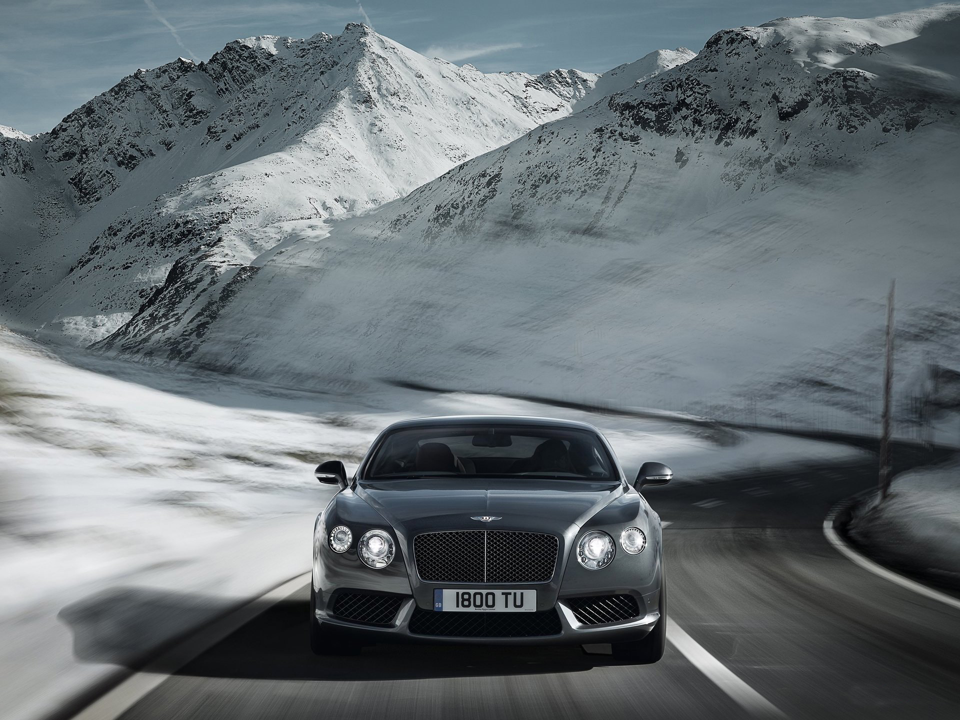 Bentley driving on a snowy mountain road HD Wallpaper