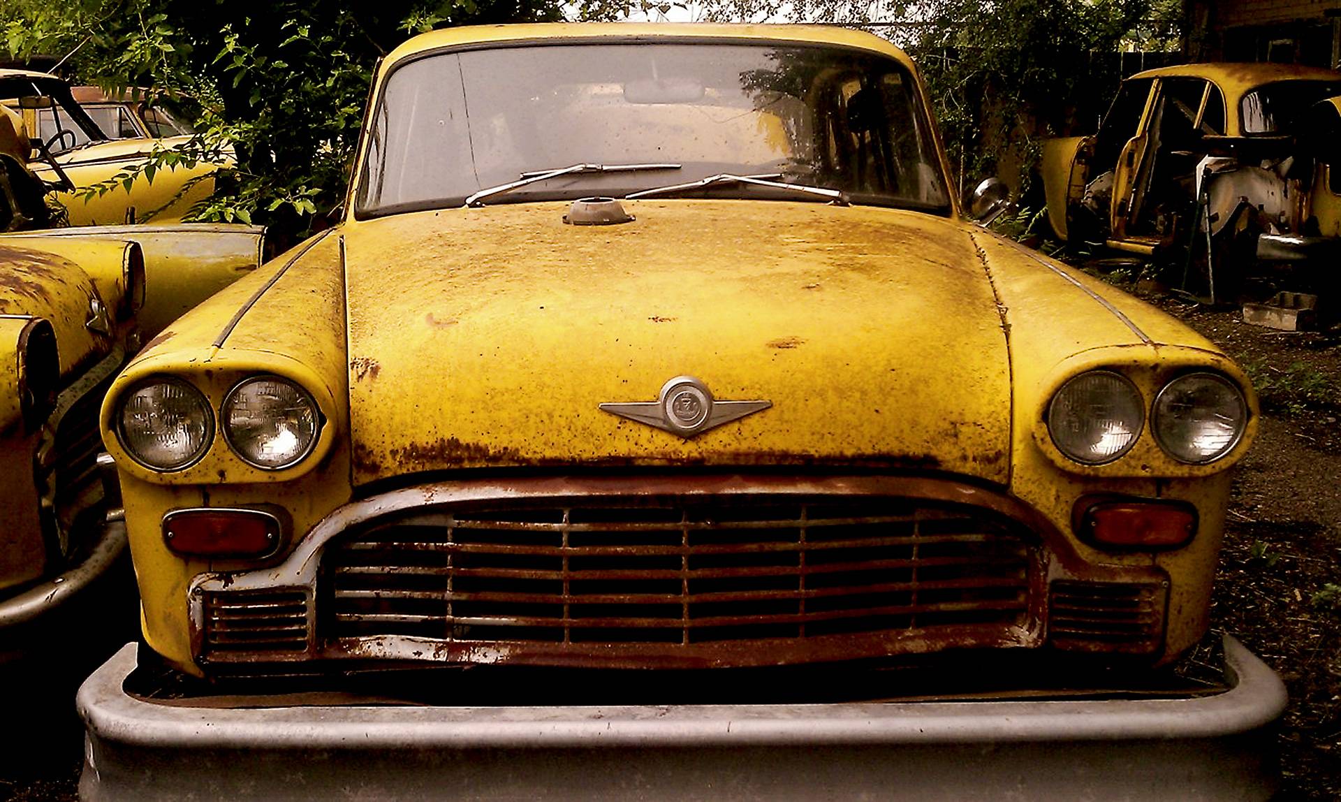 Abandoned yellow car in a junkyard HD Wallpaper