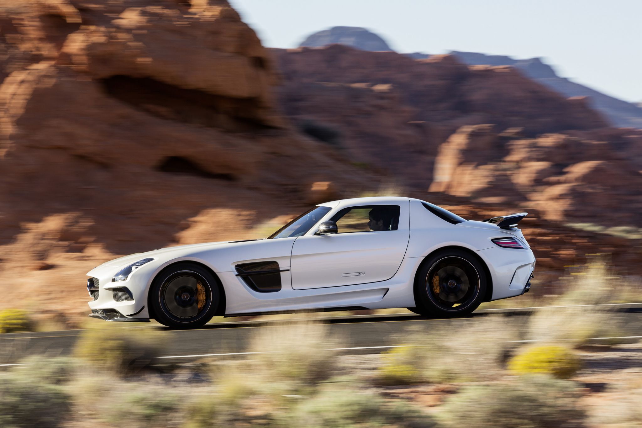 White Mercedes SLS AMG GT driving on a desert road HD Wallpaper