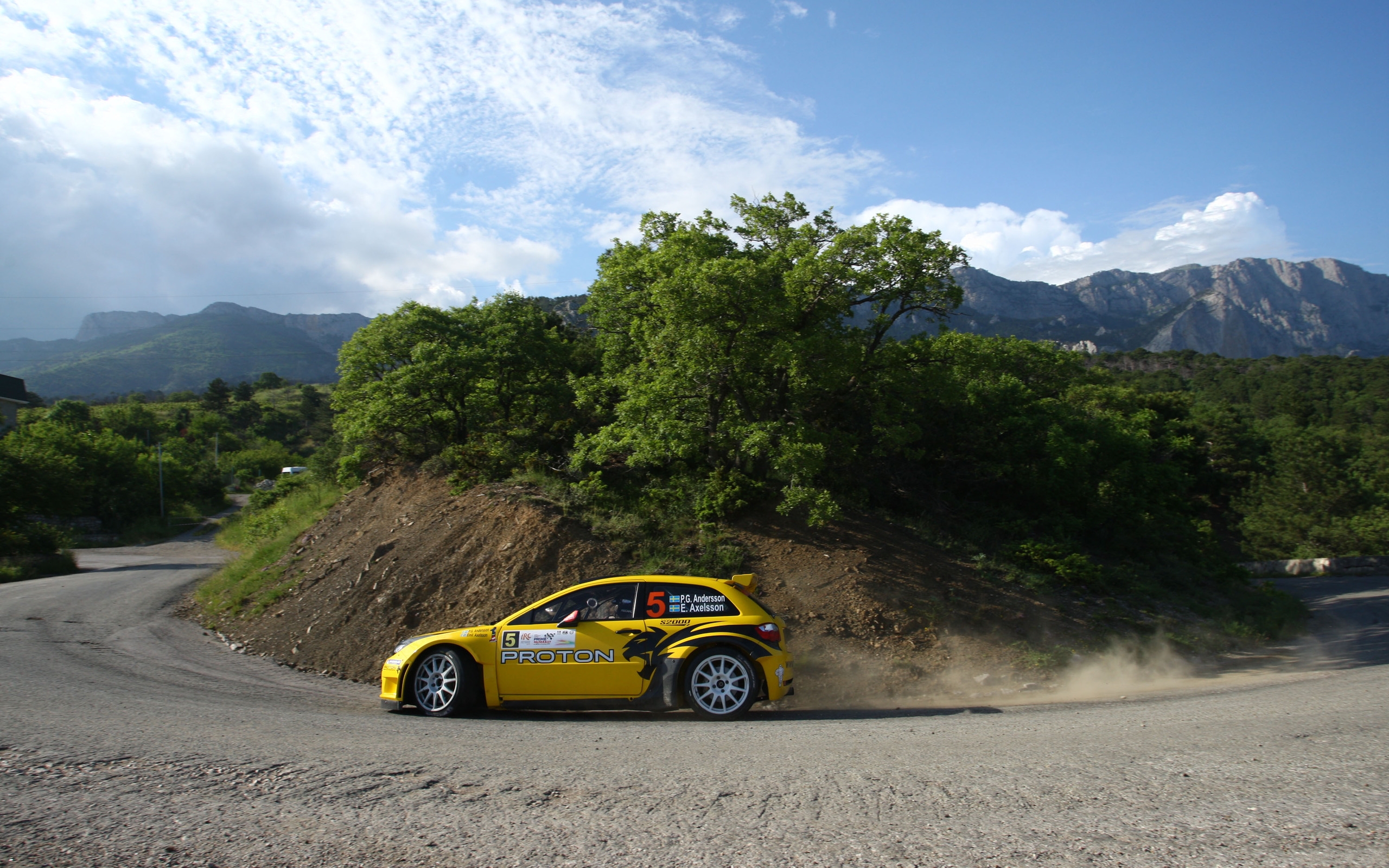 Yellow Proton rally car on a mountain road HD Wallpaper