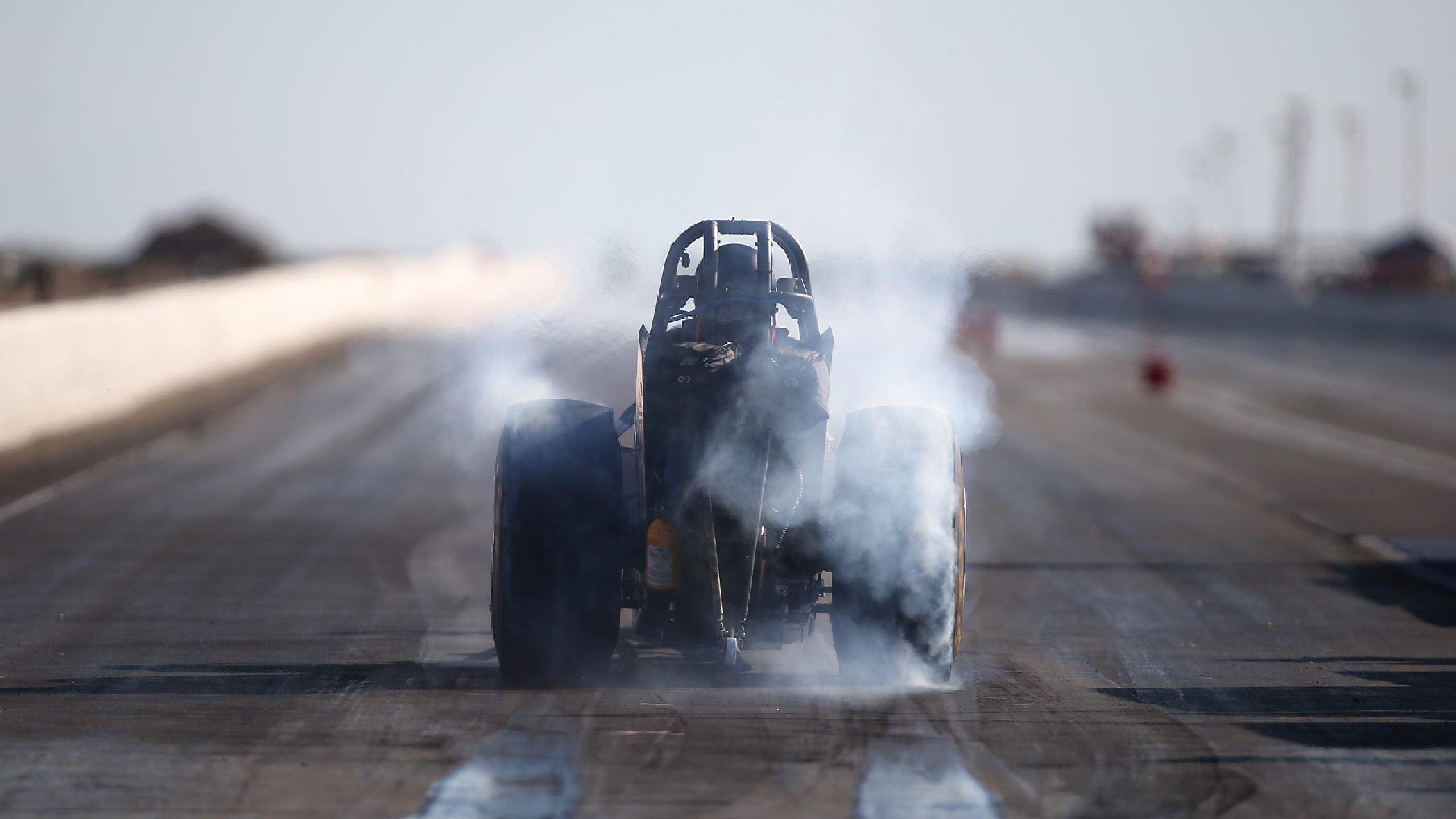 Dragster performing a burnout on a race track HD Wallpaper