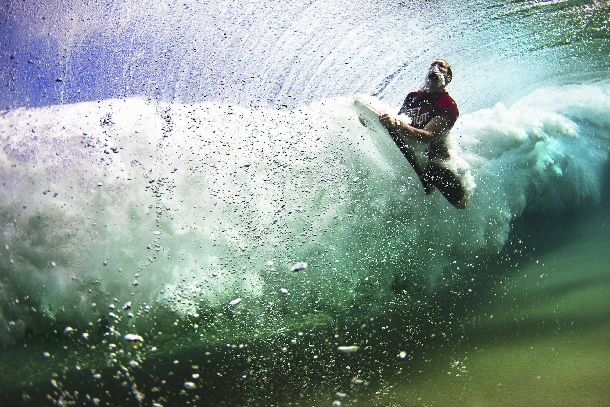 Man bodyboarding underwater in a wave HD Wallpaper