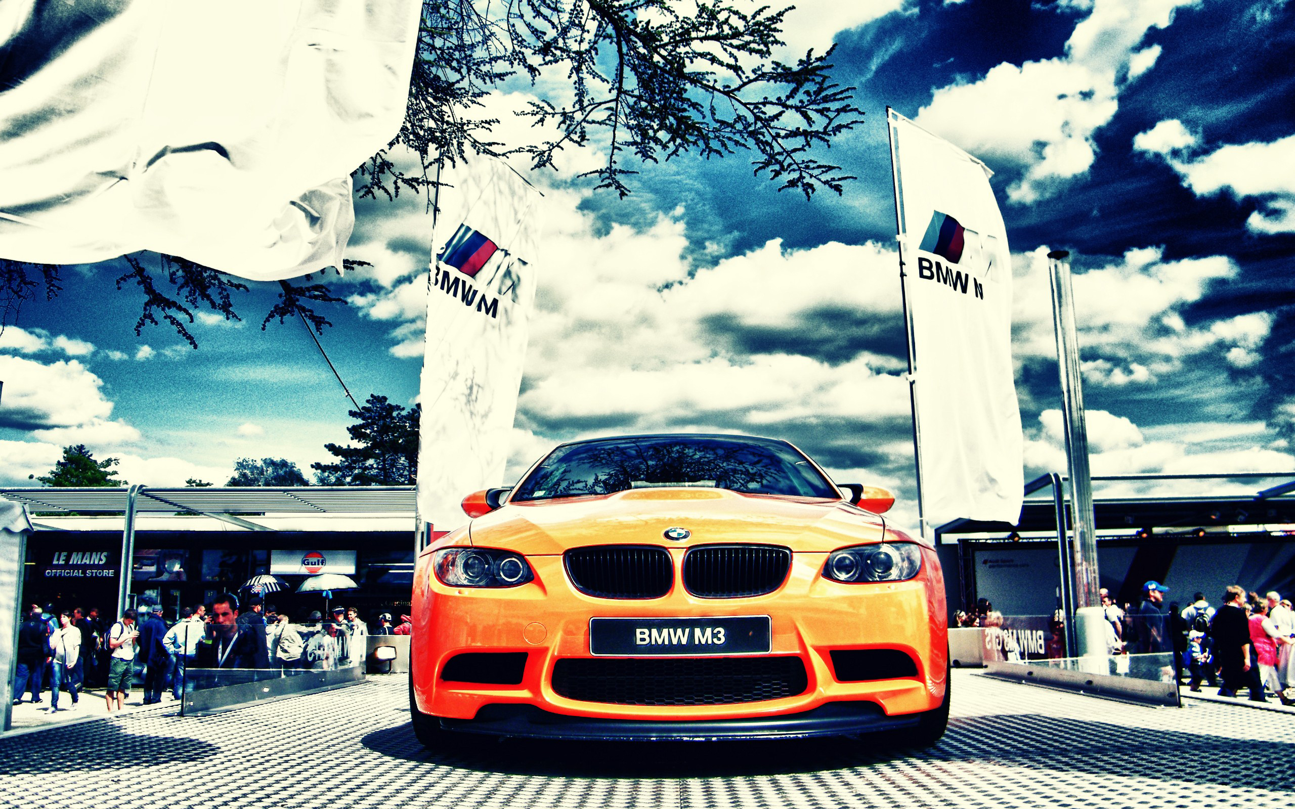 Orange BMW M3 with BMW flags at Le Mans HD Wallpaper