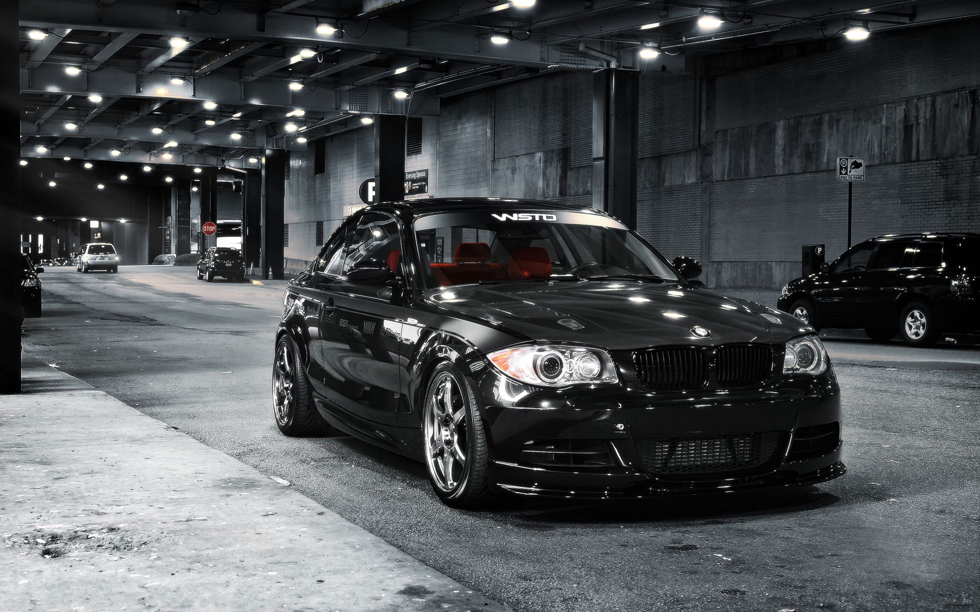 Black BMW coupe with red interior parked on city street HD Wallpaper
