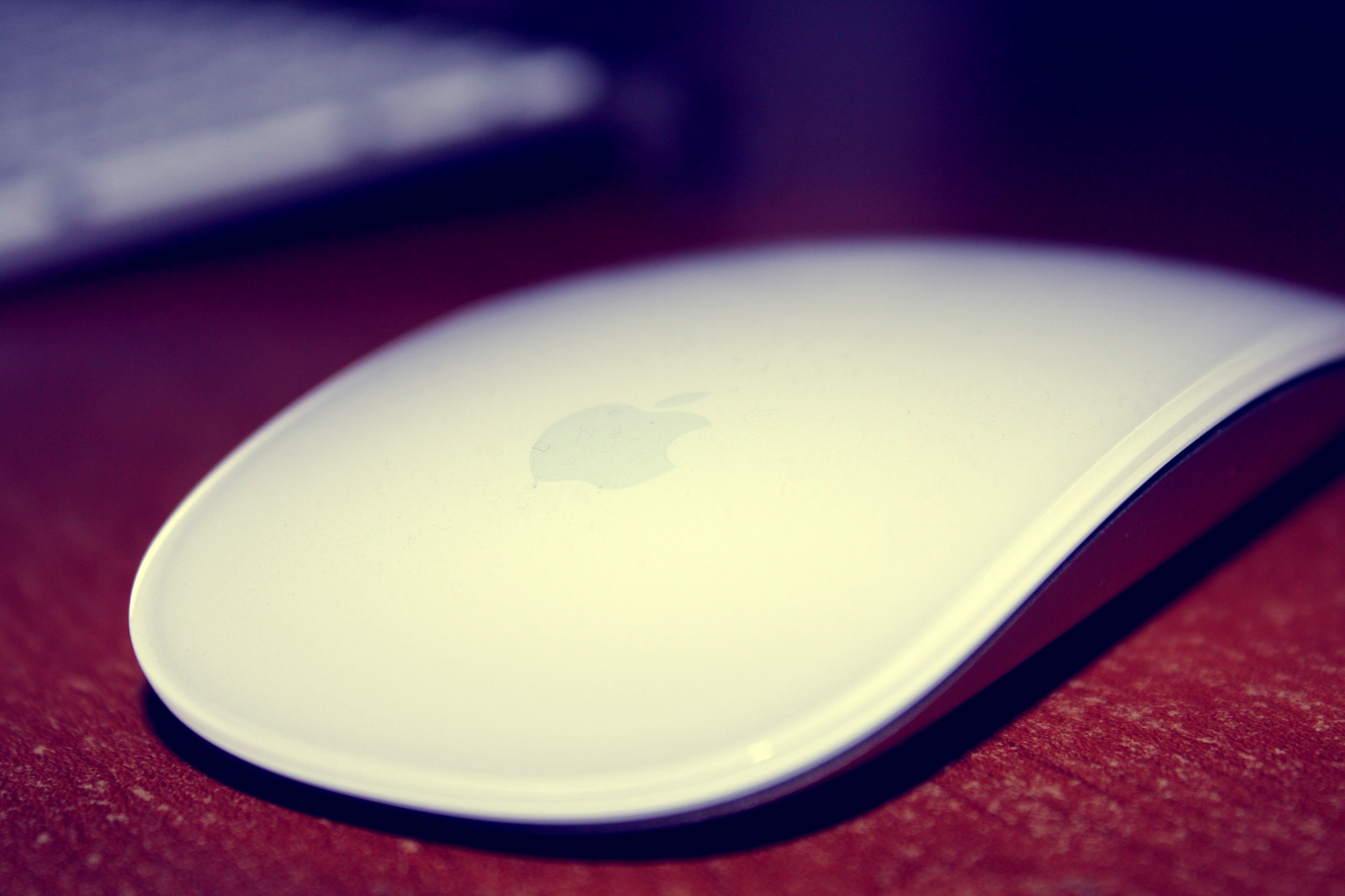 Apple Magic Mouse on a wooden desk HD Wallpaper