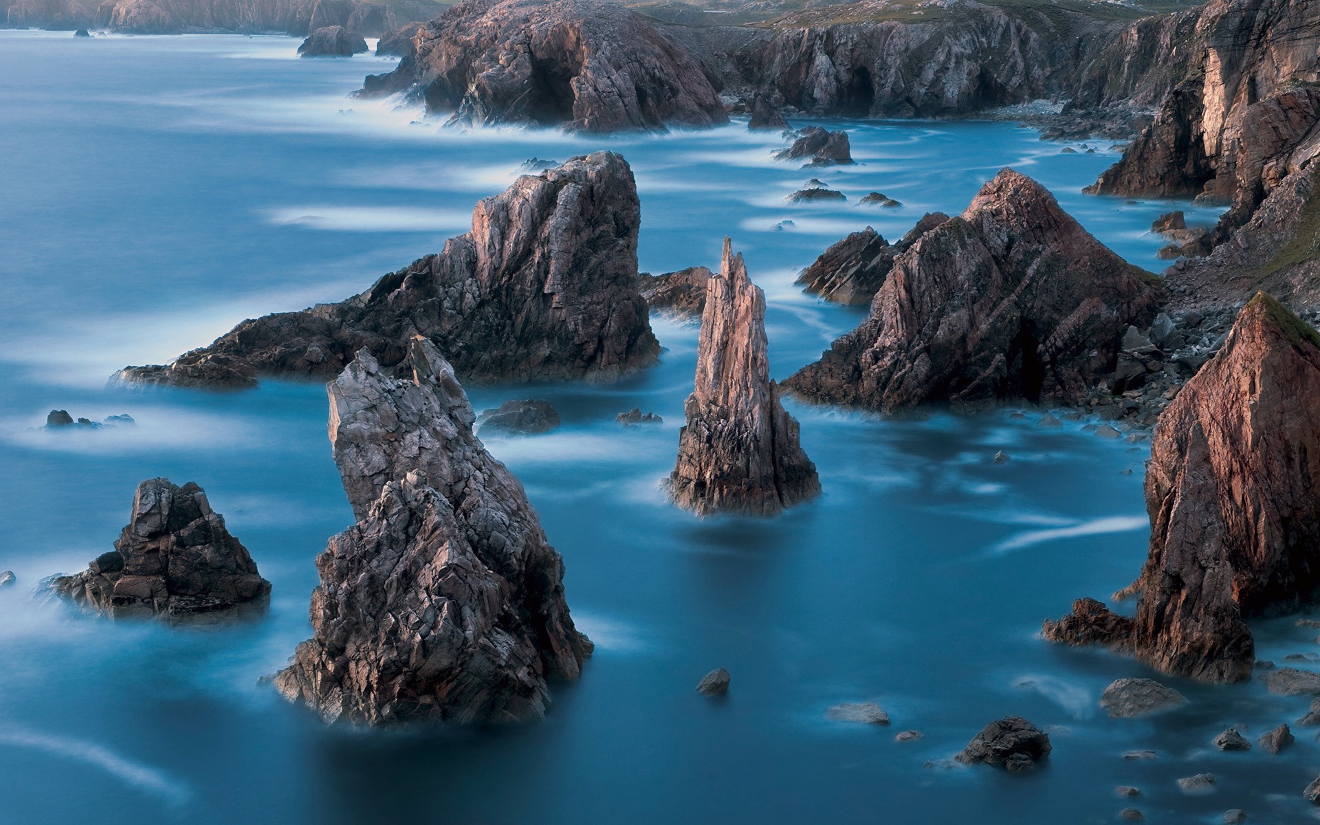 Jagged coastal rocks in the ocean at dusk HD Wallpaper