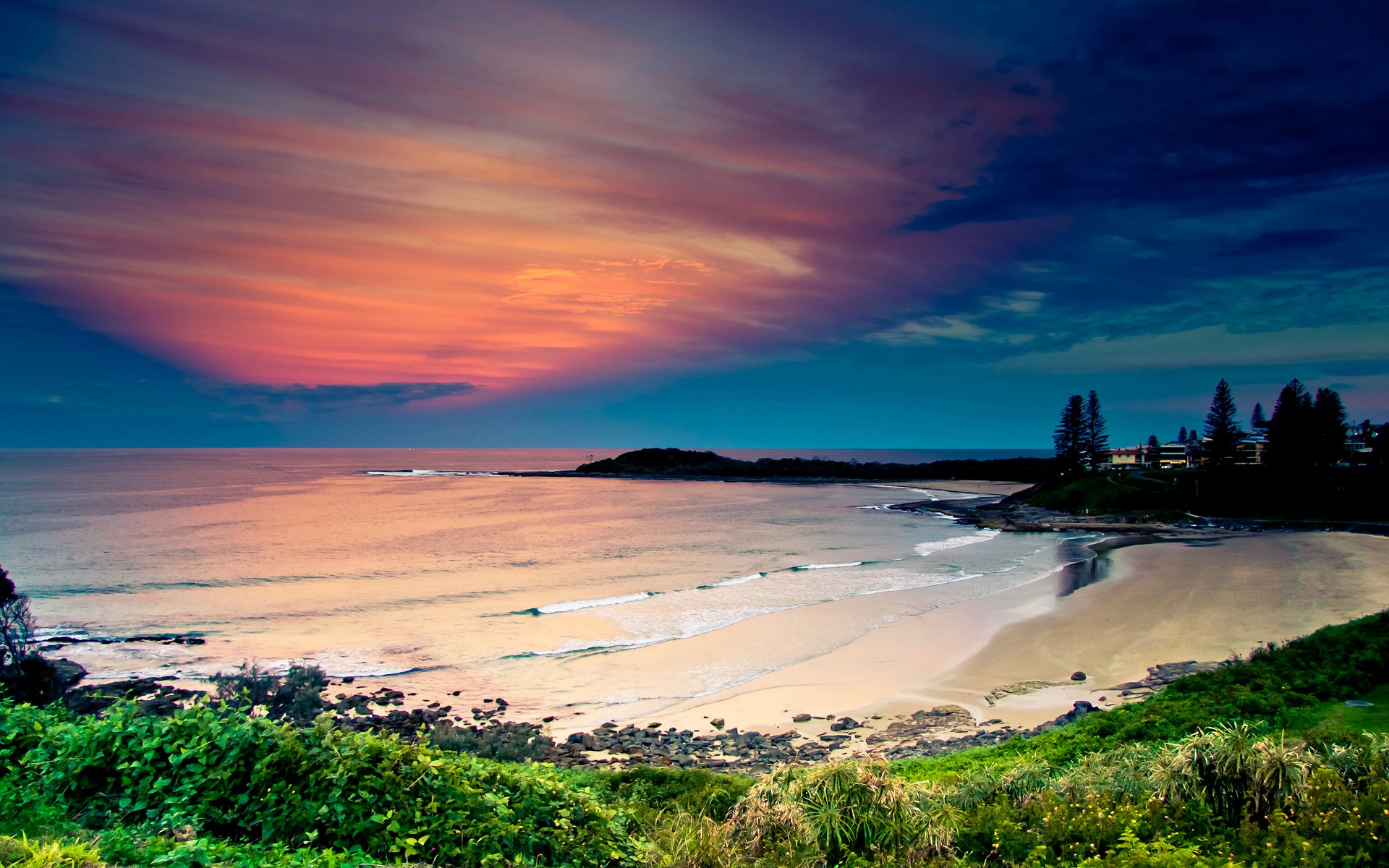 Beach at sunset with colorful sky and ocean waves HD Wallpaper