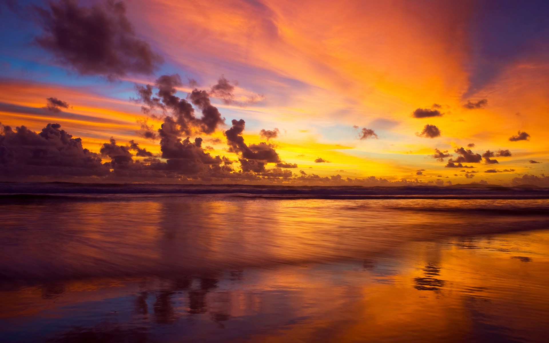 Sunset over a beach with colorful clouds and reflections HD Wallpaper