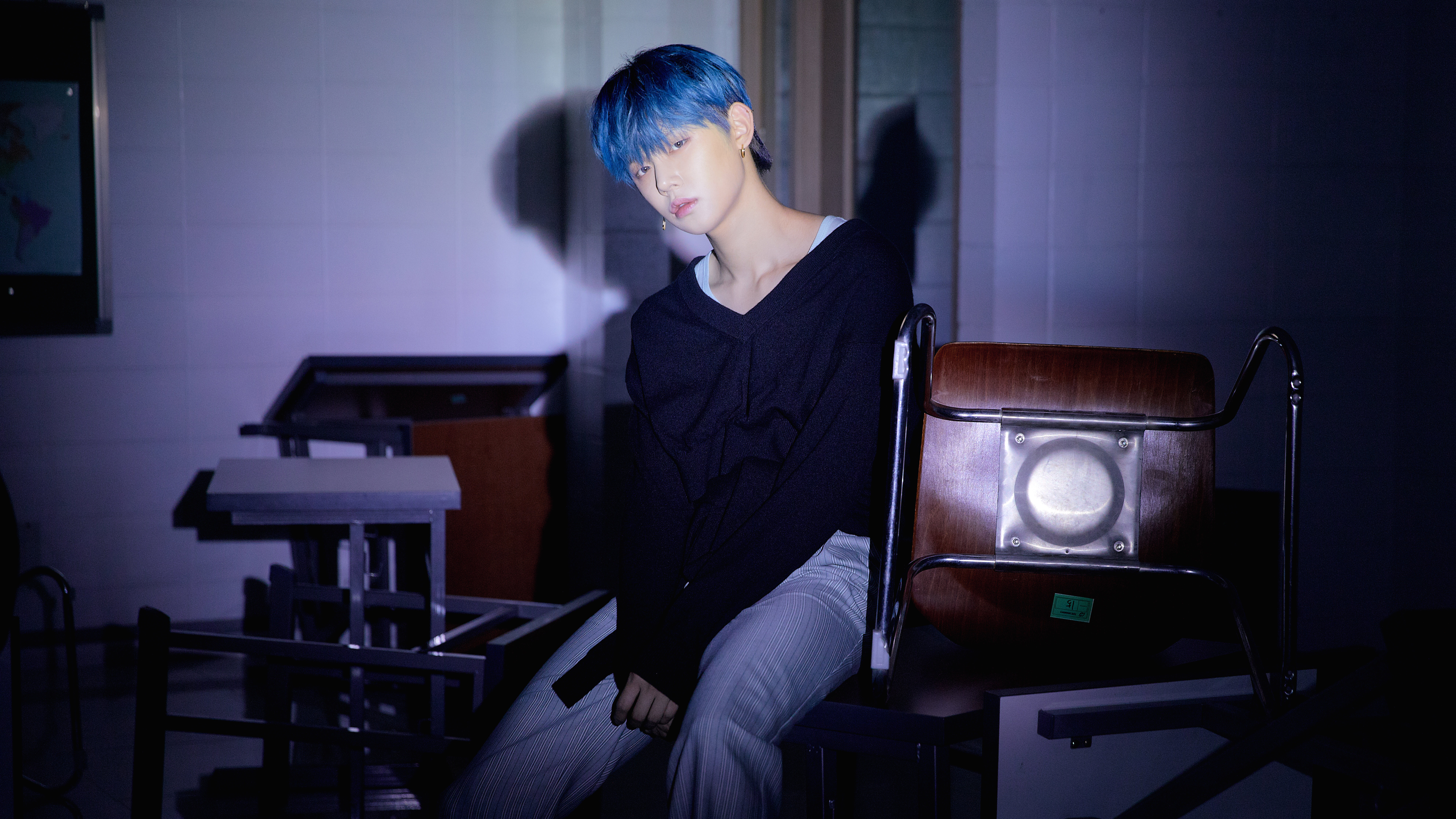 Man with blue hair sitting in a room HD Wallpaper