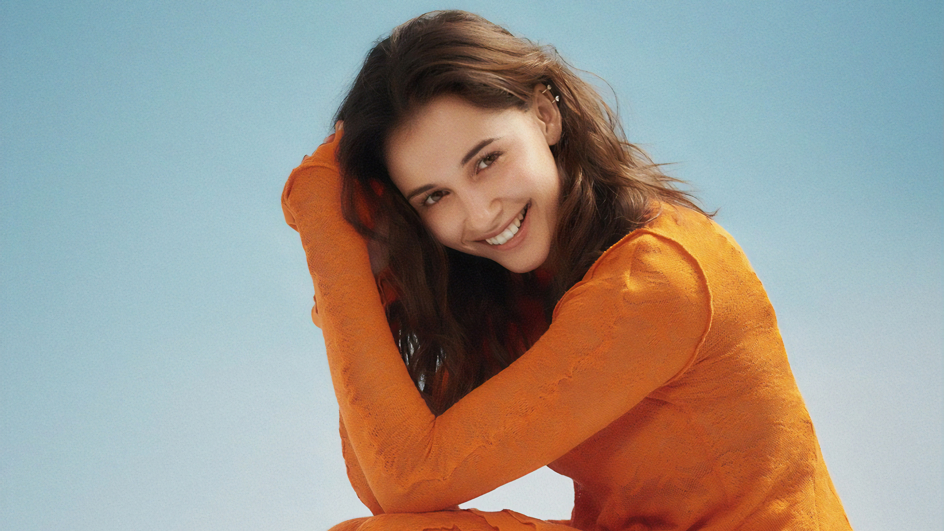 Naomi Scott smiling in orange outfit HD Wallpaper