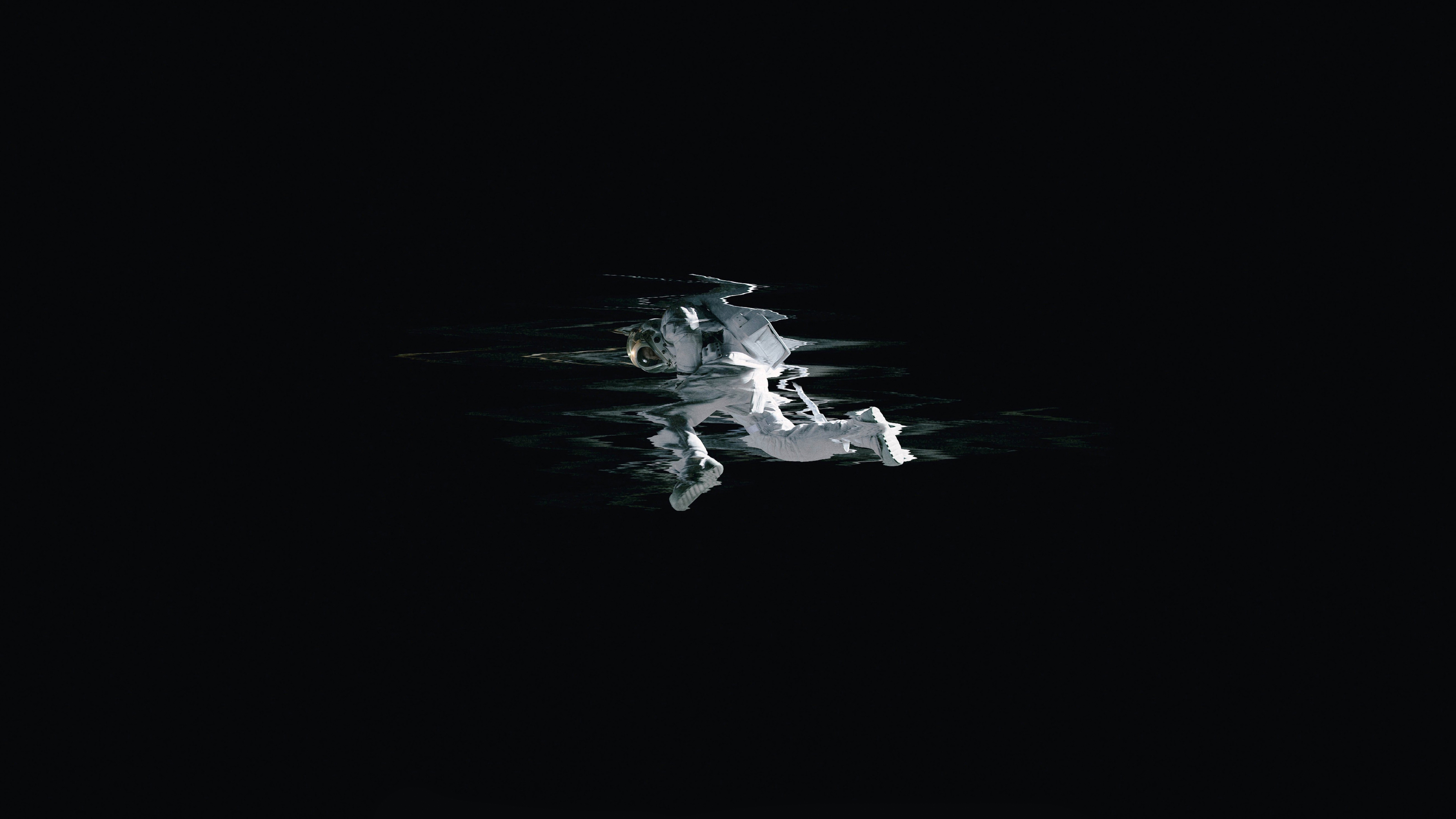 Astronaut floating on dark water HD Wallpaper