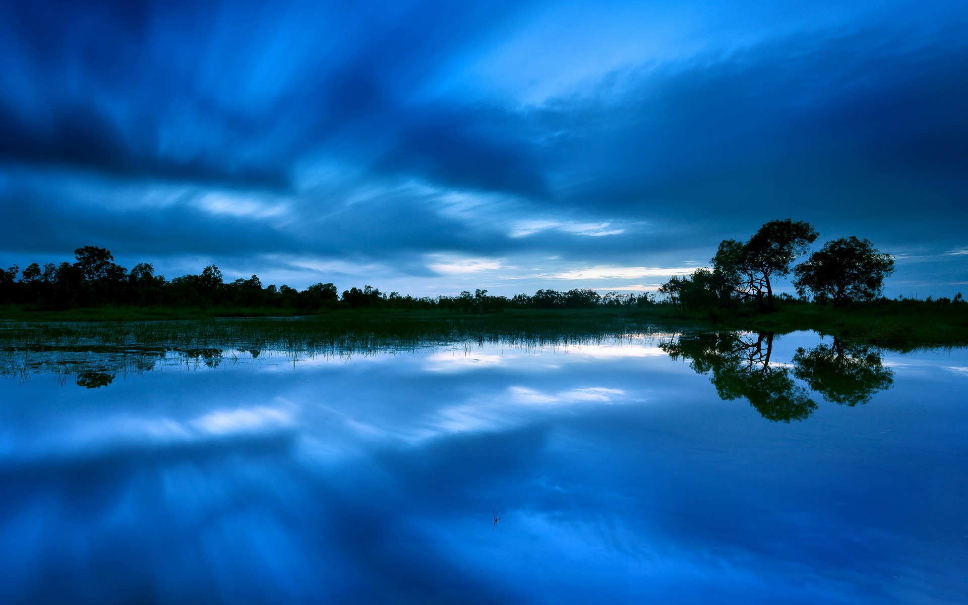 Blue sky reflected in a calm lake at dusk HD Wallpaper