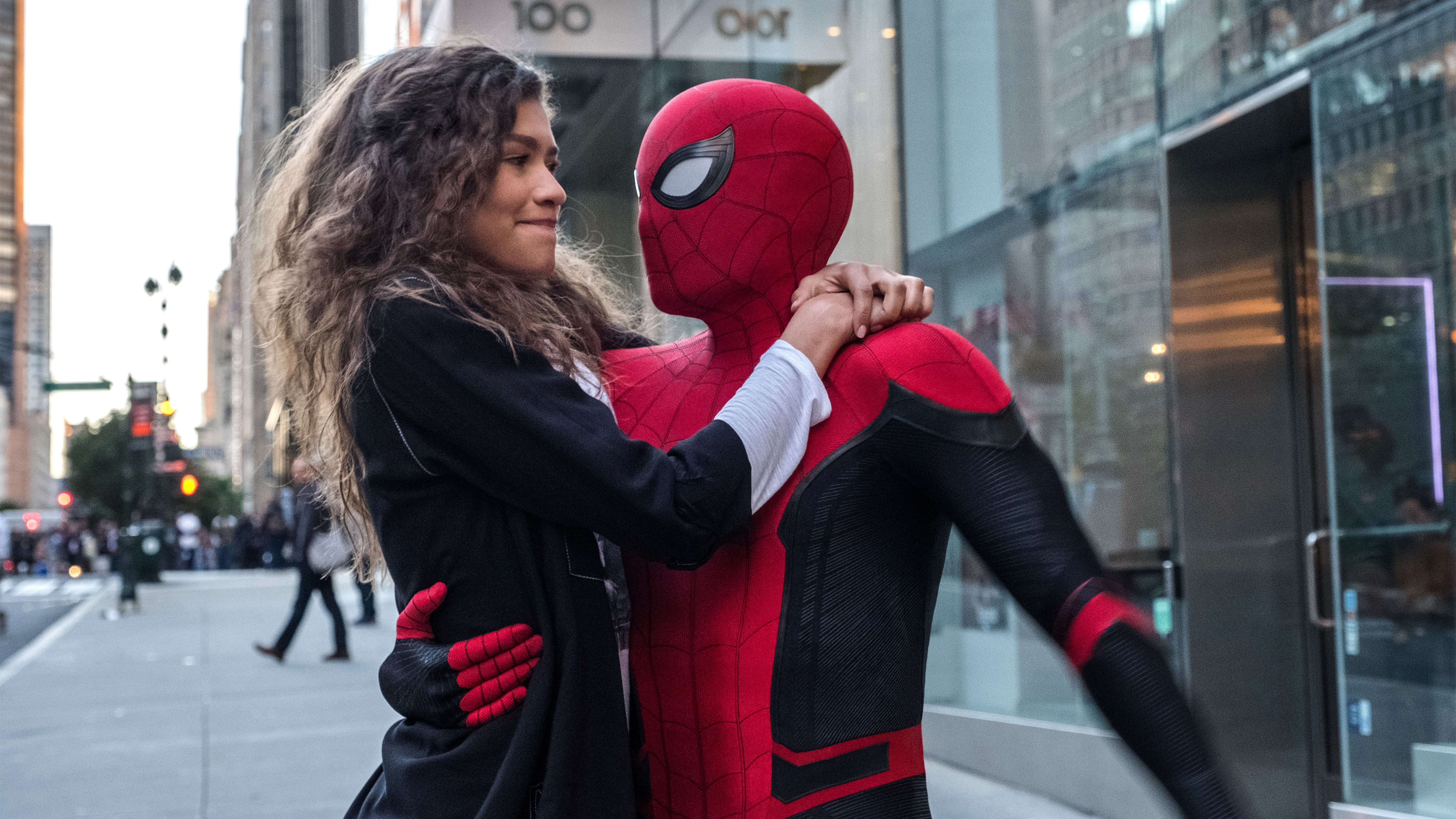 Spider-Man and MJ embrace on a city street HD Wallpaper