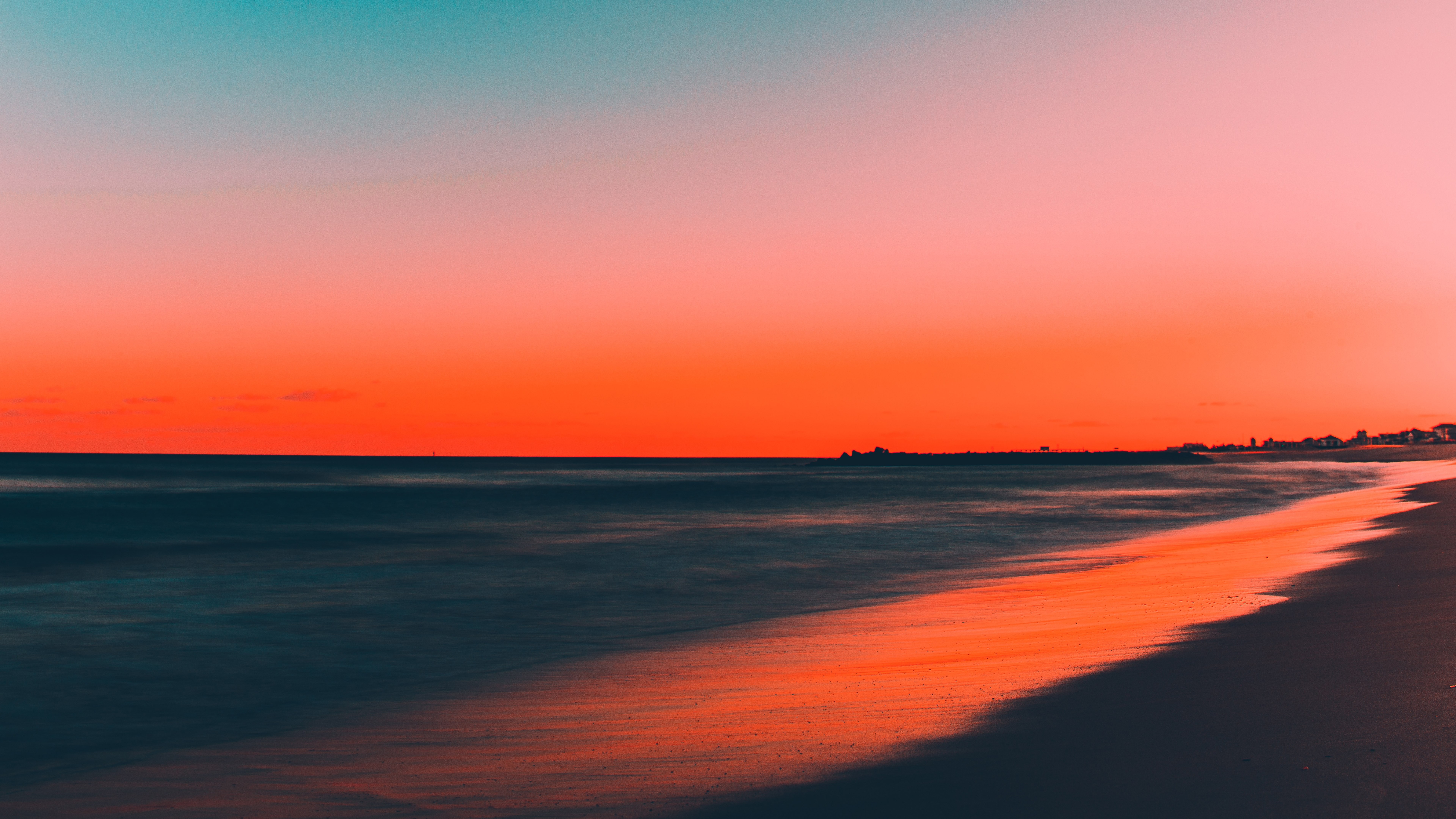 Beach at sunset with colorful sky and ocean waves HD Wallpaper