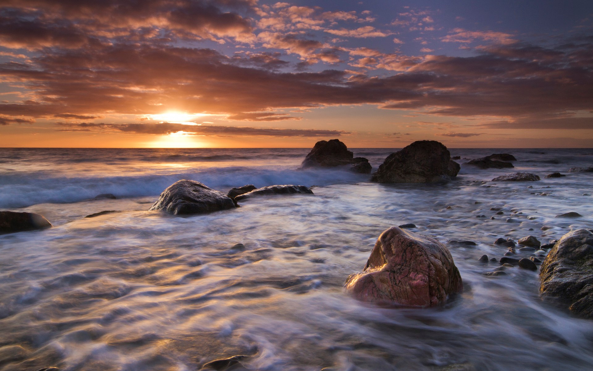 Sunset over rocky ocean shore with waves HD Wallpaper