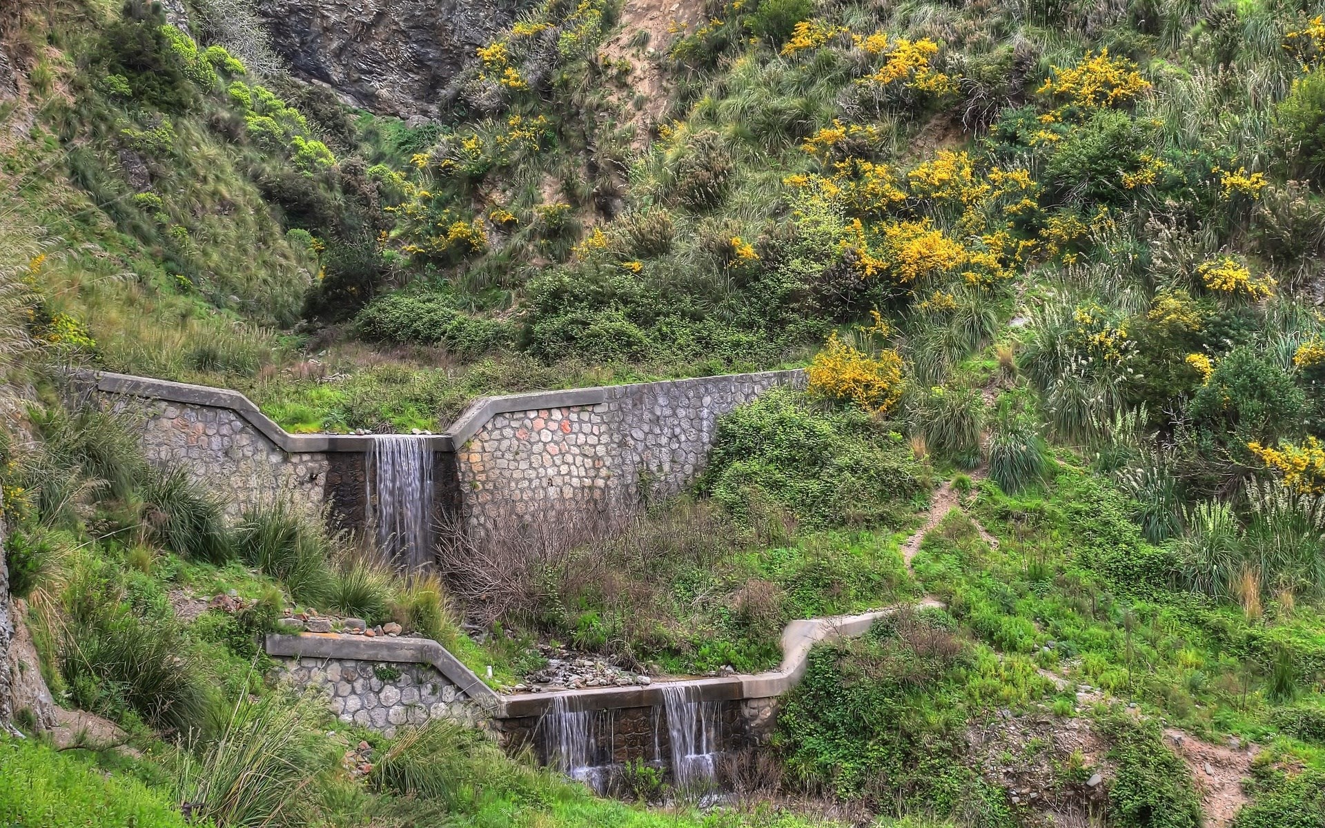 Terraced waterfall with stone walls and green vegetation HD Wallpaper