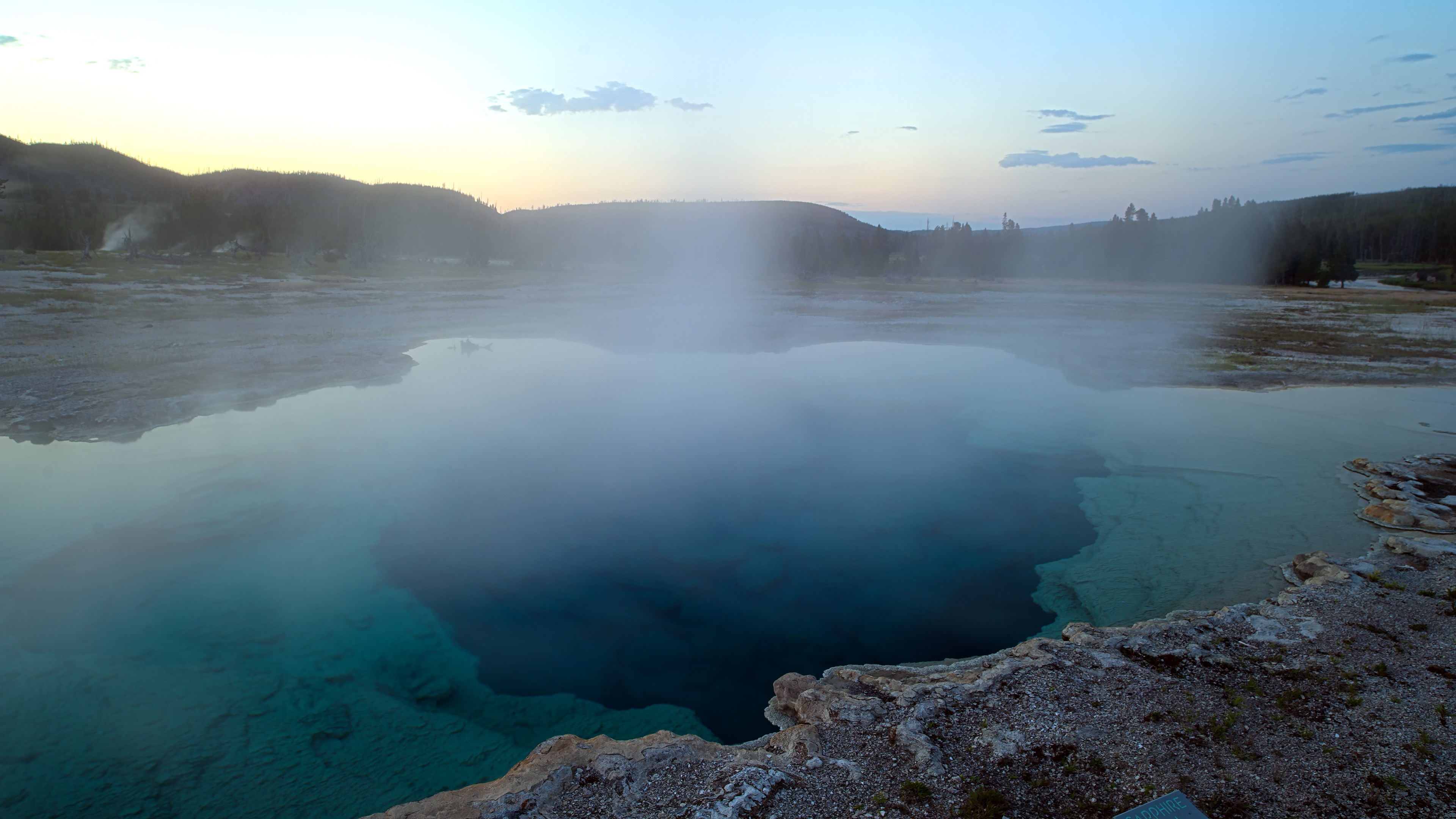Steam rising from a geothermal pool at sunrise HD Wallpaper
