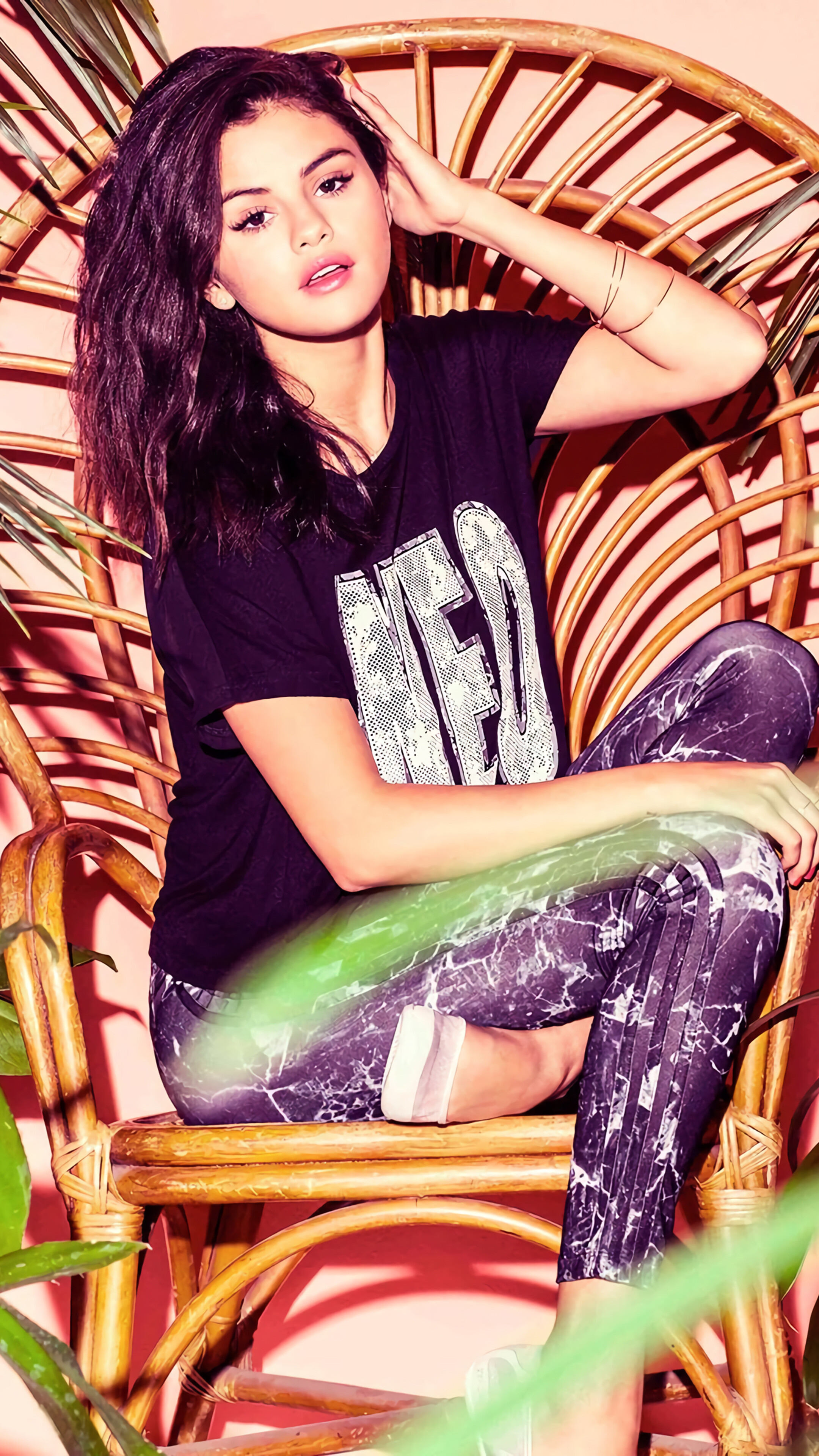 Selena Gomez in a wicker chair HD Phone Wallpaper