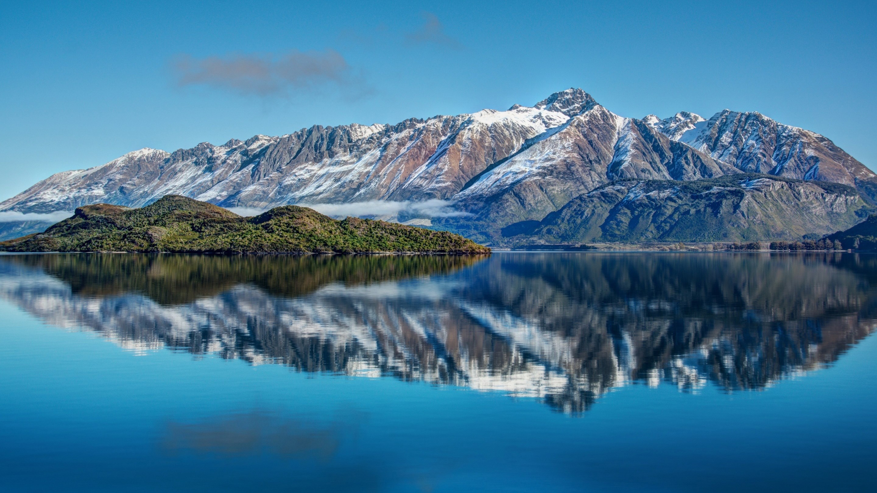 Snow-capped mountains reflected in a calm lake HD Wallpaper