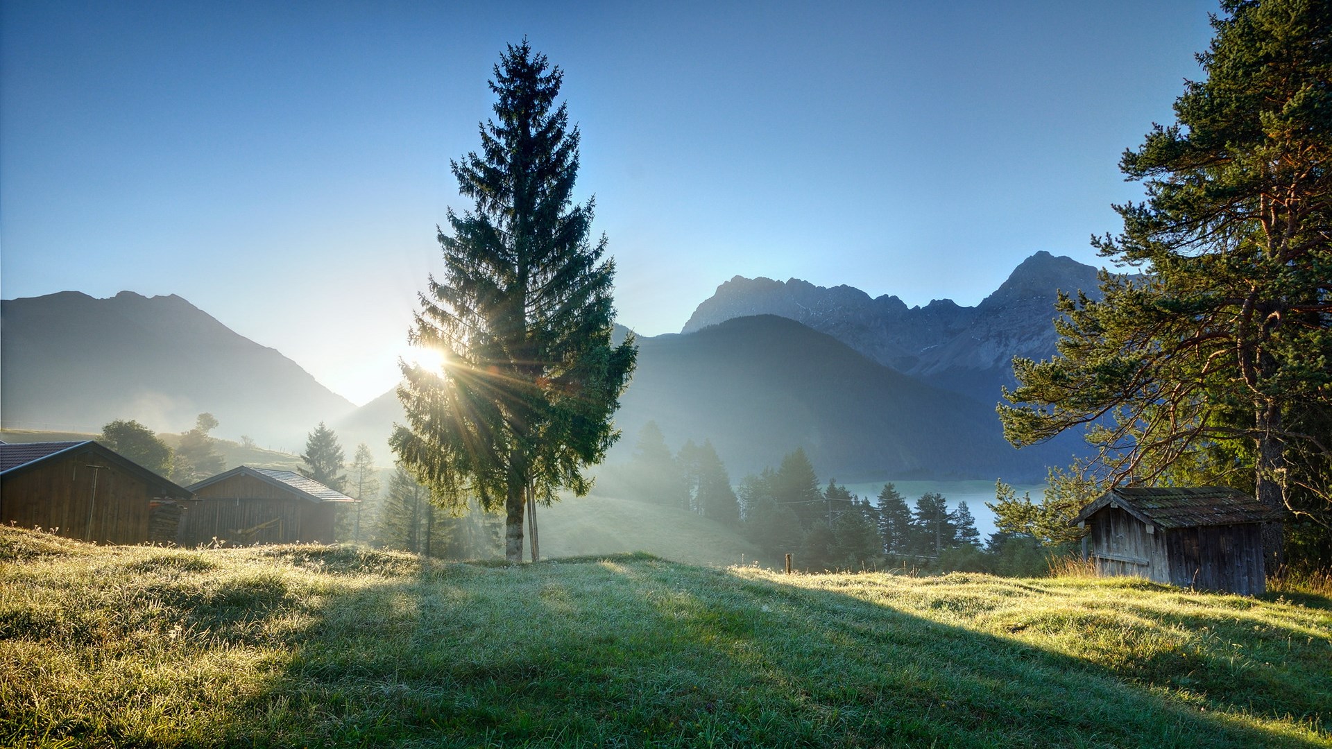 Sunrise over a mountain valley with cabins and trees HD Wallpaper