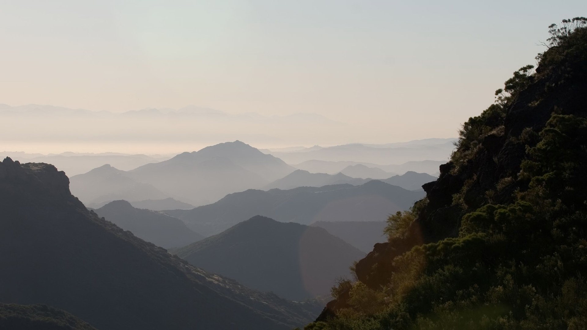 Layered mountains in haze at sunrise HD Wallpaper