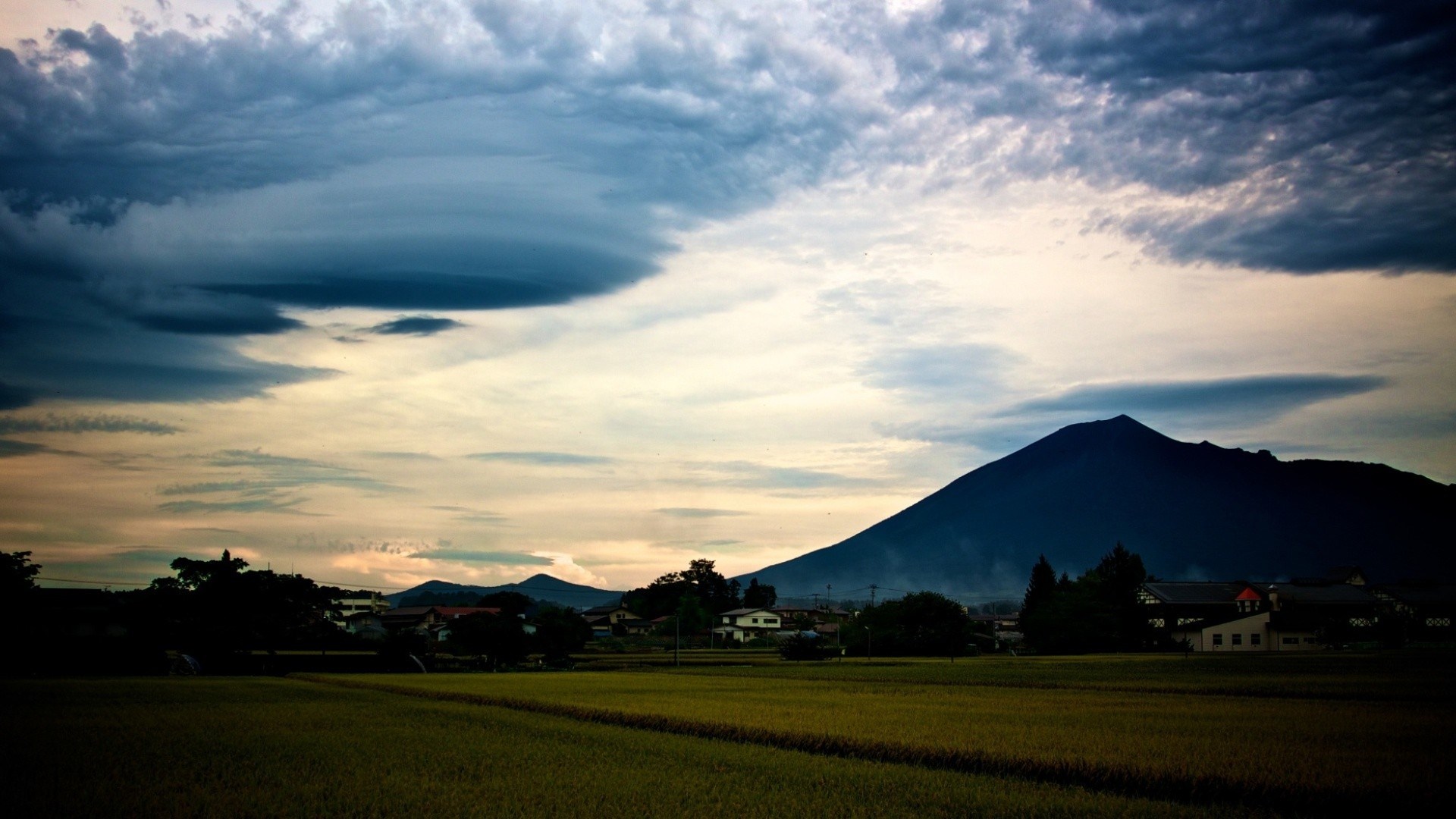 Mountain and field under cloudy sky HD Wallpaper