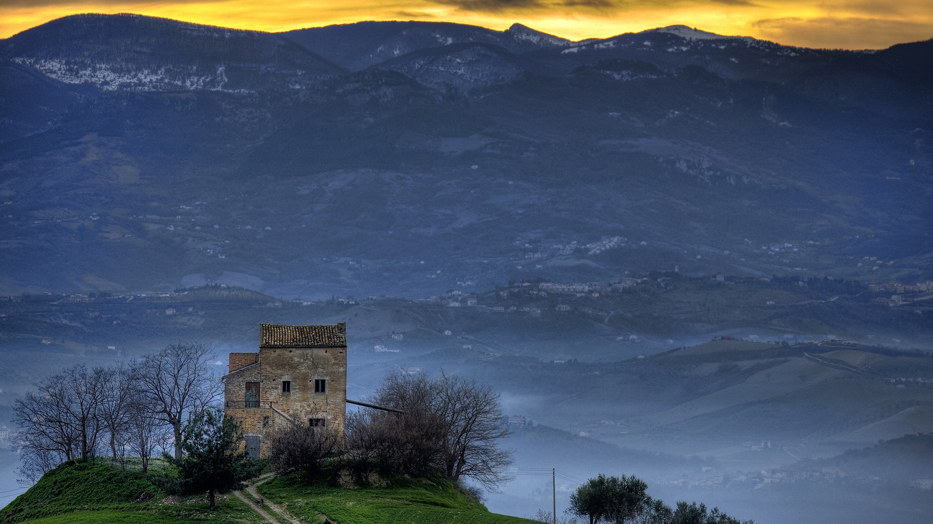 Old building on a hill with mountains in the background HD Wallpaper