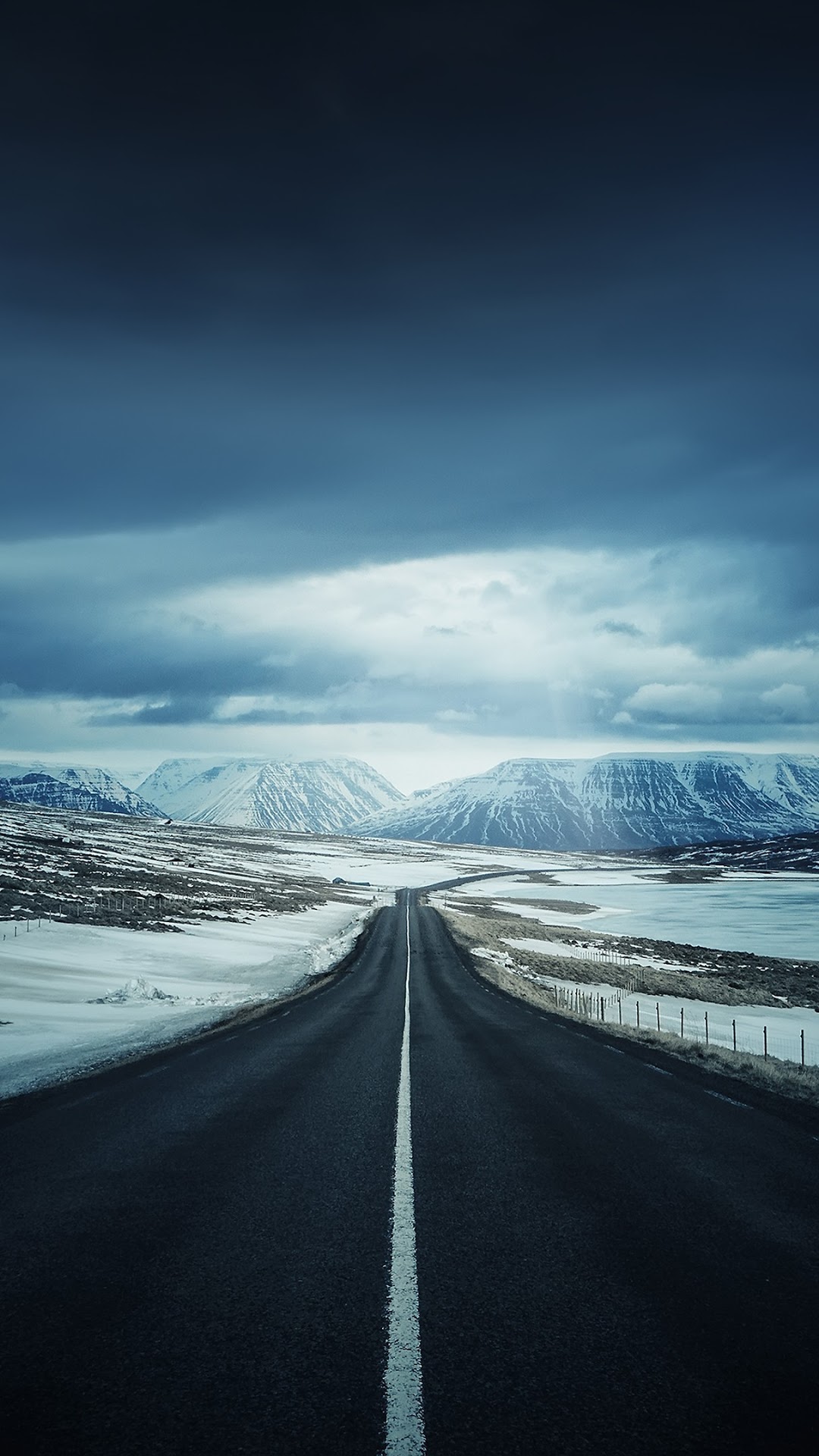 Road through snowy mountains under cloudy sky HD Phone Wallpaper