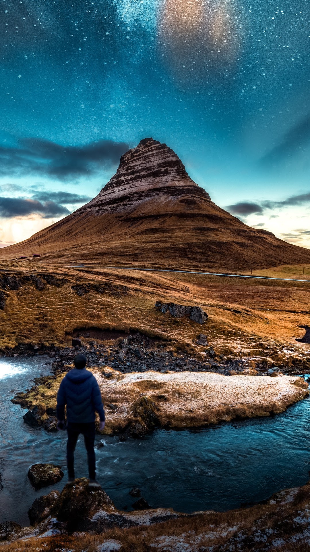 Man standing by river with Kirkjufell mountain and stars HD Phone Wallpaper