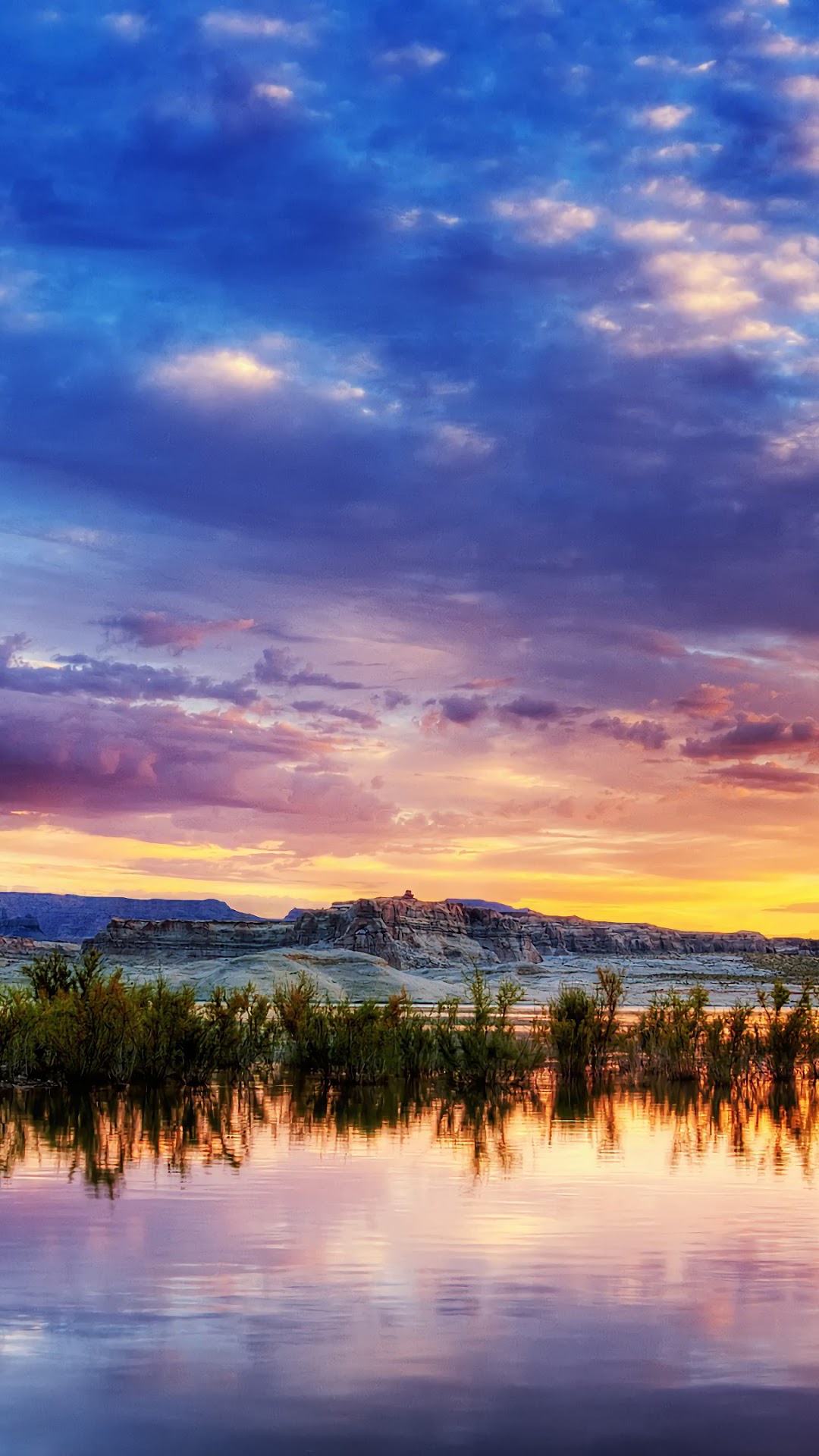 Sunset over a lake with mountains and vegetation HD Phone Wallpaper