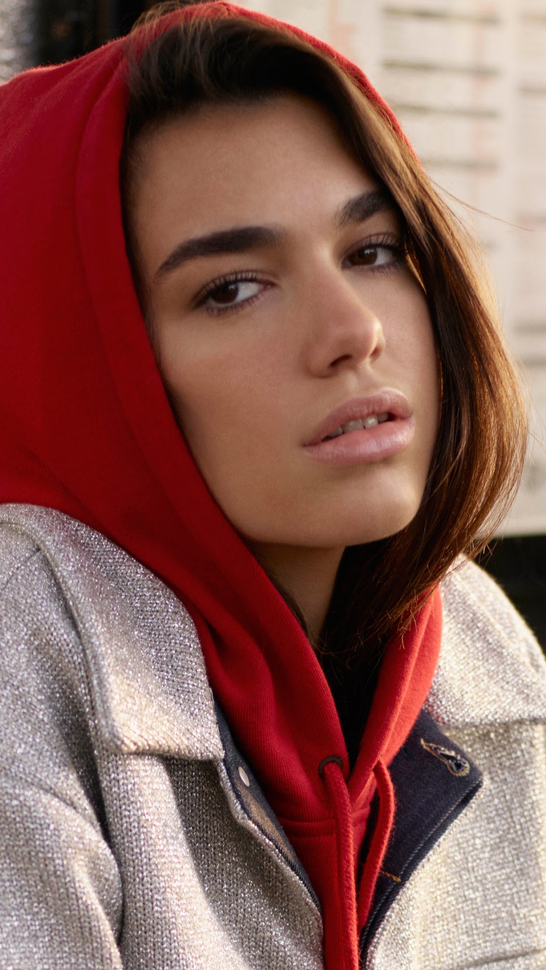 Dua Lipa wearing a red hoodie and silver jacket HD Phone Wallpaper