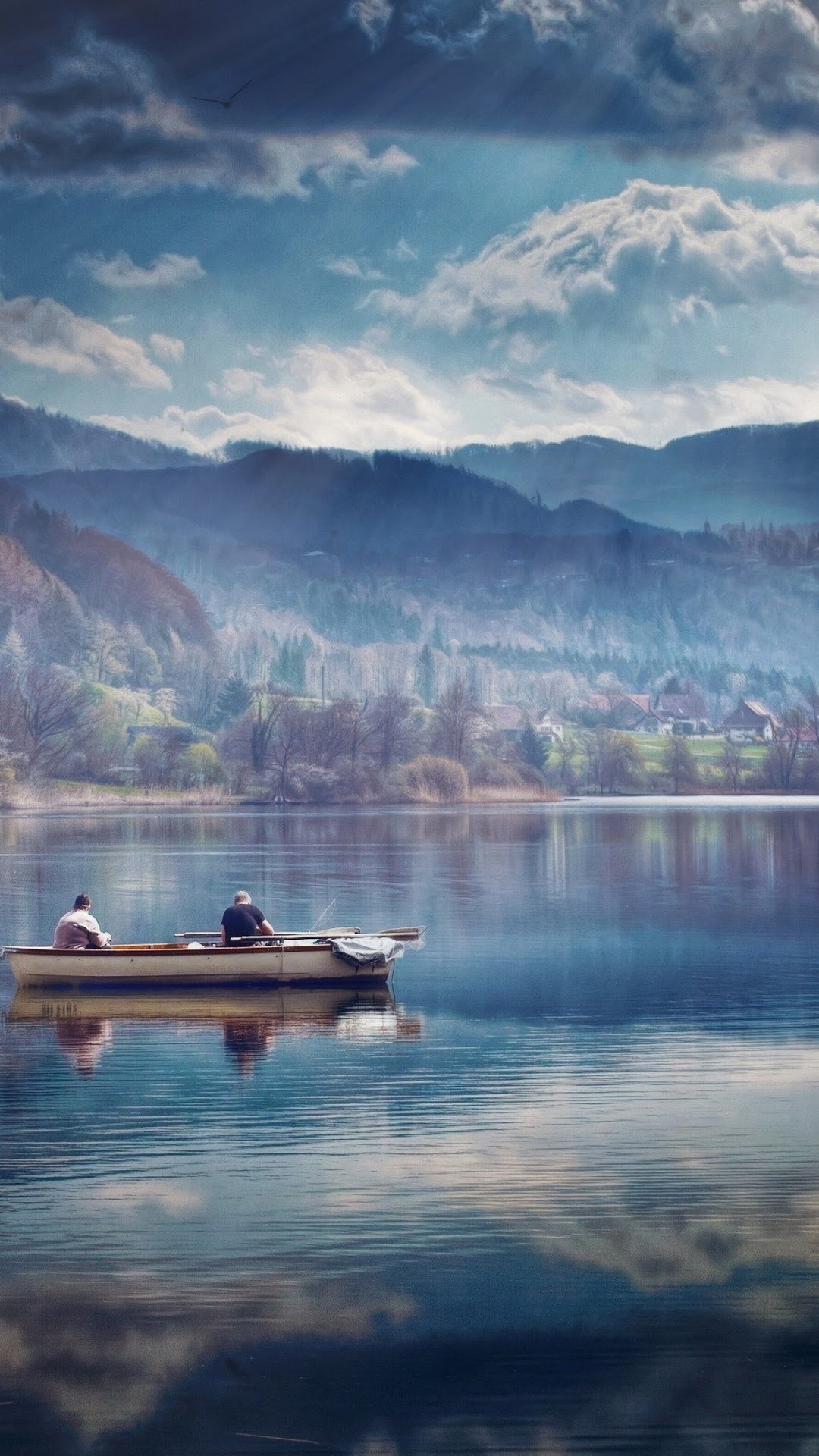 Two people fishing in a boat on a lake with mountains in the background HD Phone Wallpaper