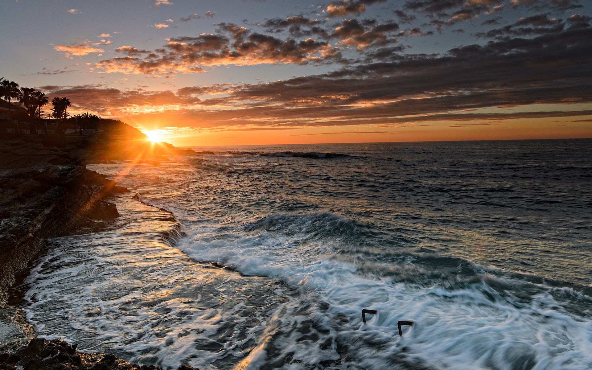 Sunset over the ocean with rocky shore HD Wallpaper