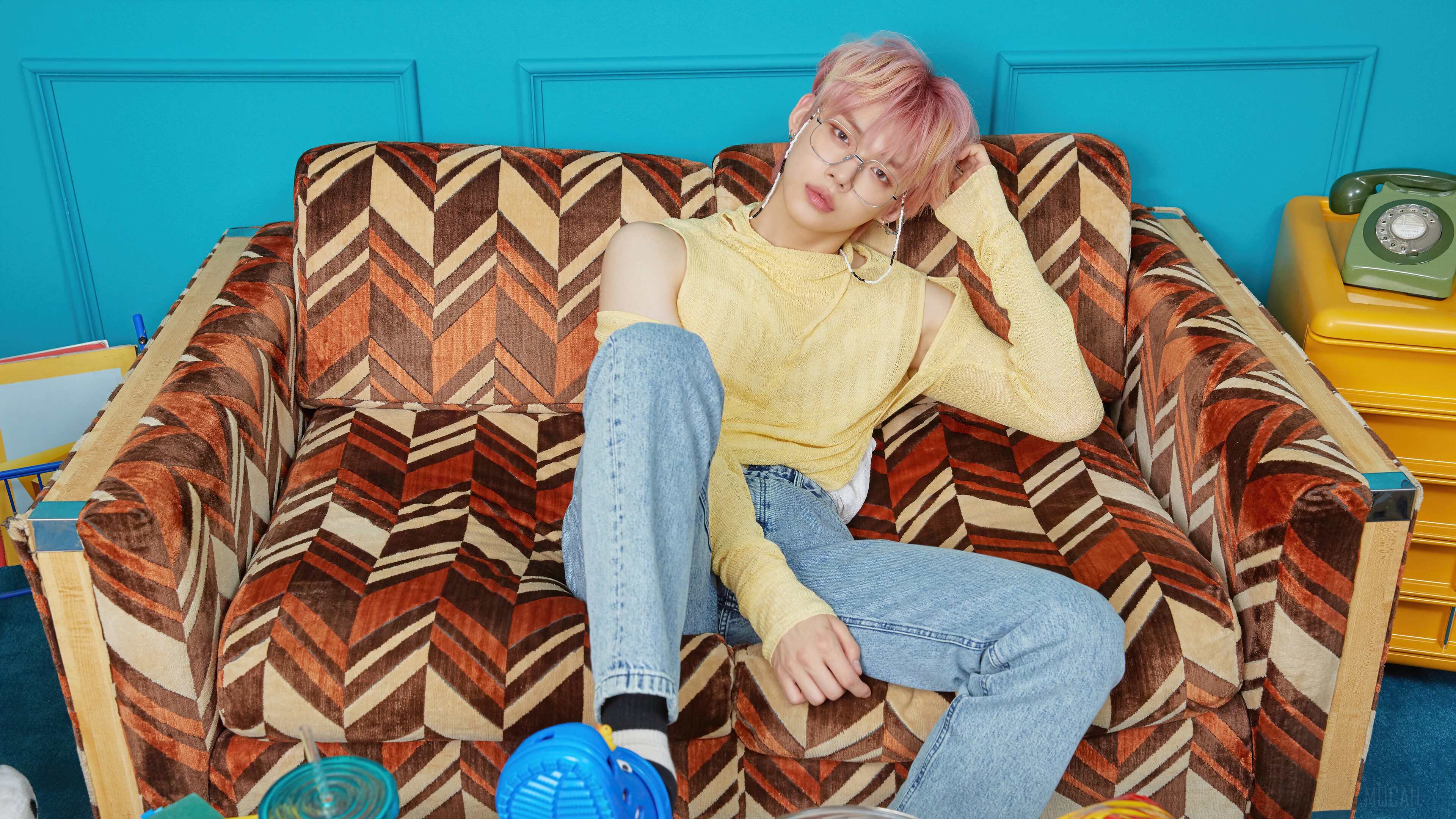 Yeonjun from TXT on a patterned couch HD Wallpaper