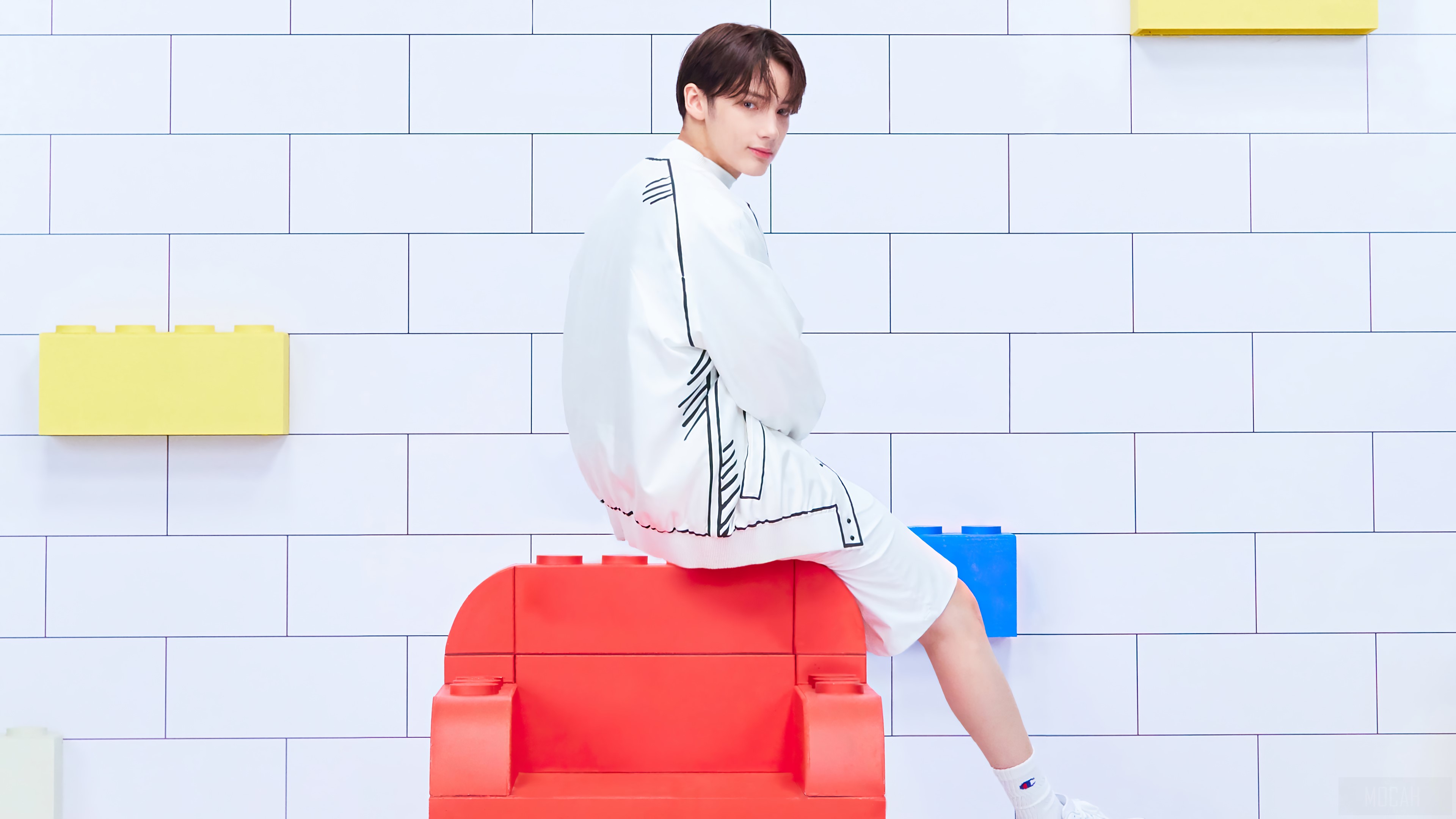 Huening Kai from TXT sitting on a red Lego chair HD Wallpaper