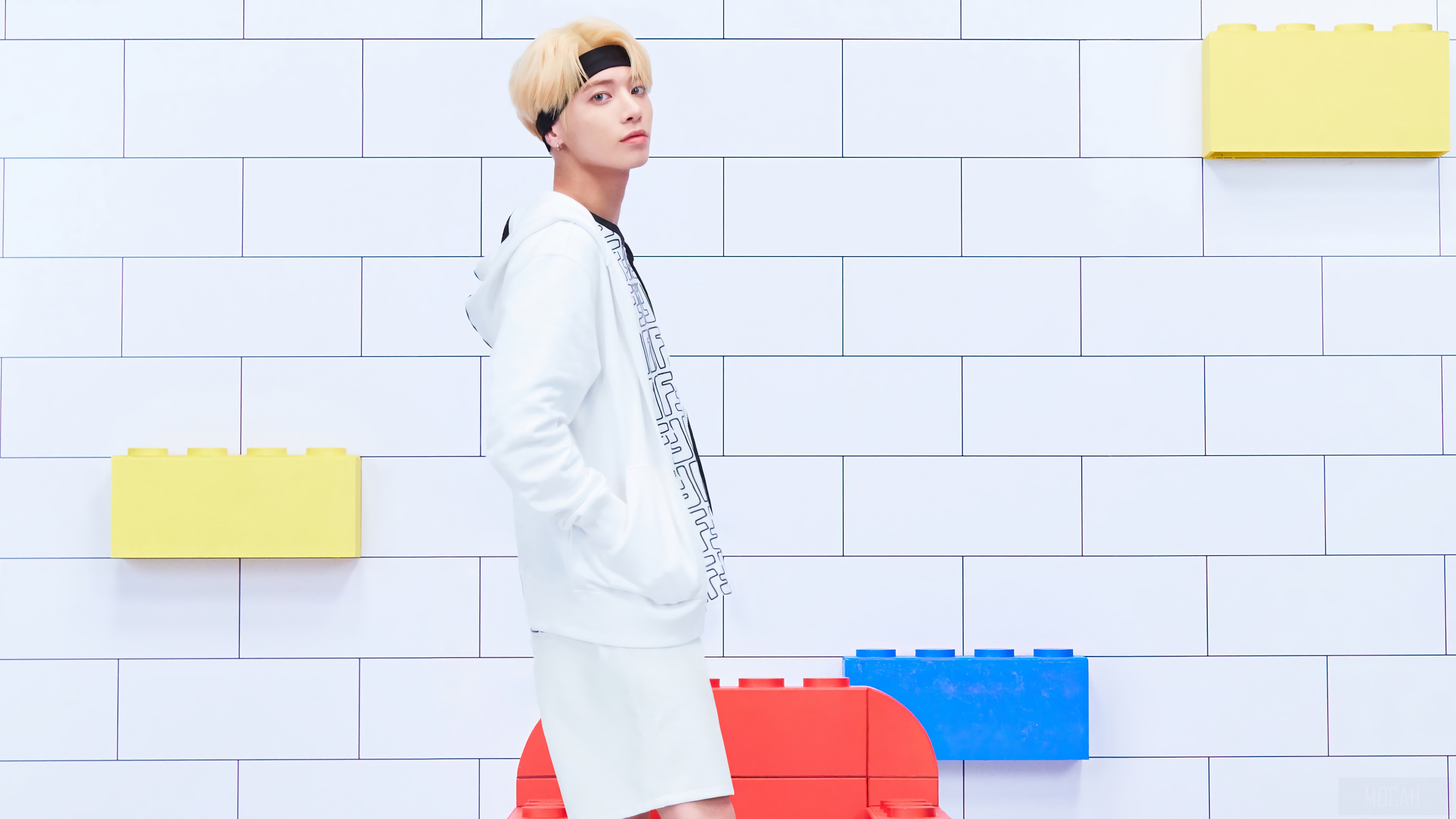Taehyun from TXT in front of a brick wall with toy blocks HD Wallpaper