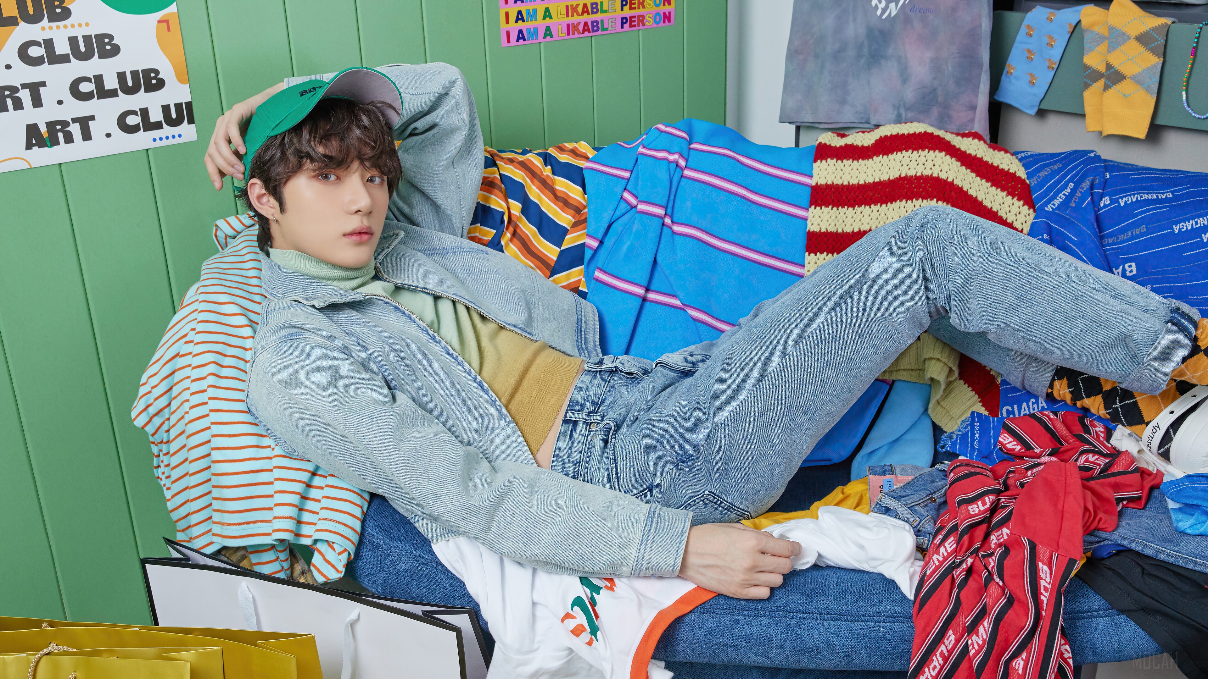 Choi Beomgyu from TXT in a colorful, cluttered room HD Wallpaper