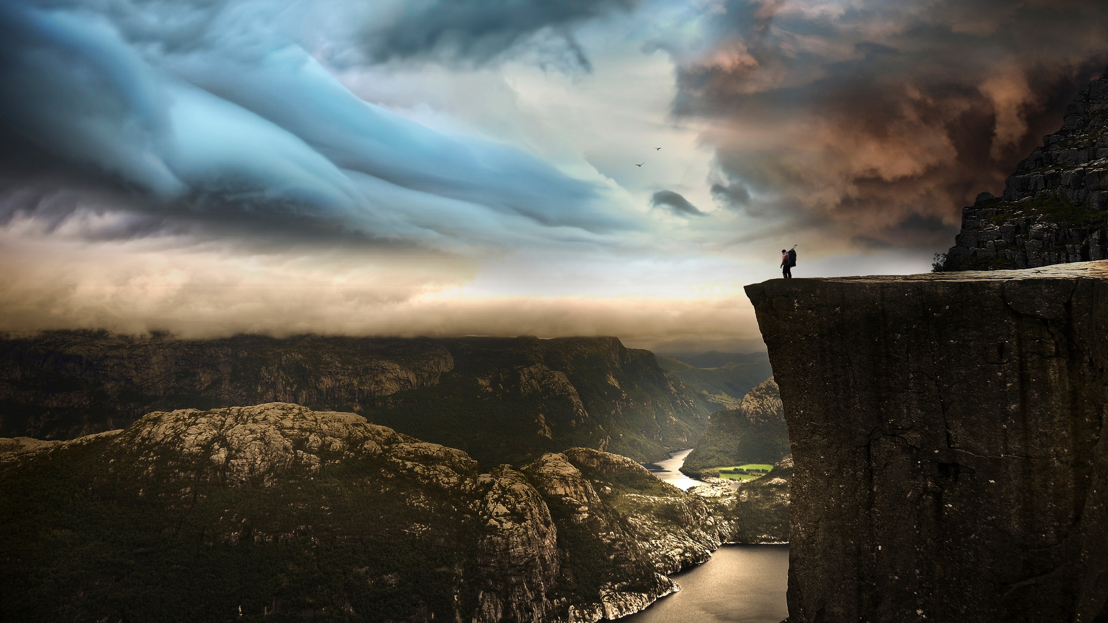Hiker on Preikestolen cliff overlooking Lysefjorden HD Wallpaper