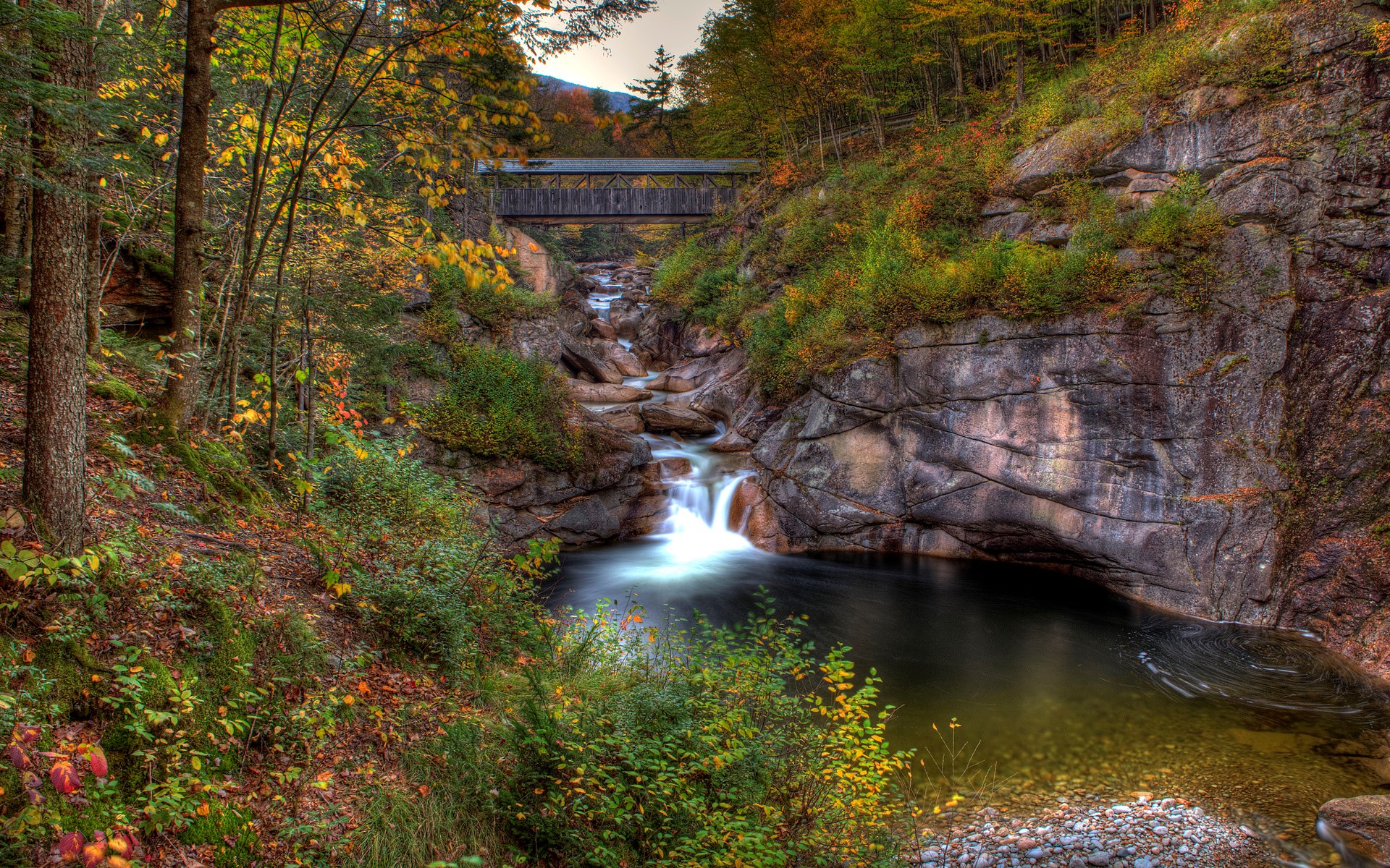 Covered bridge over a waterfall in autumn forest HD Wallpaper