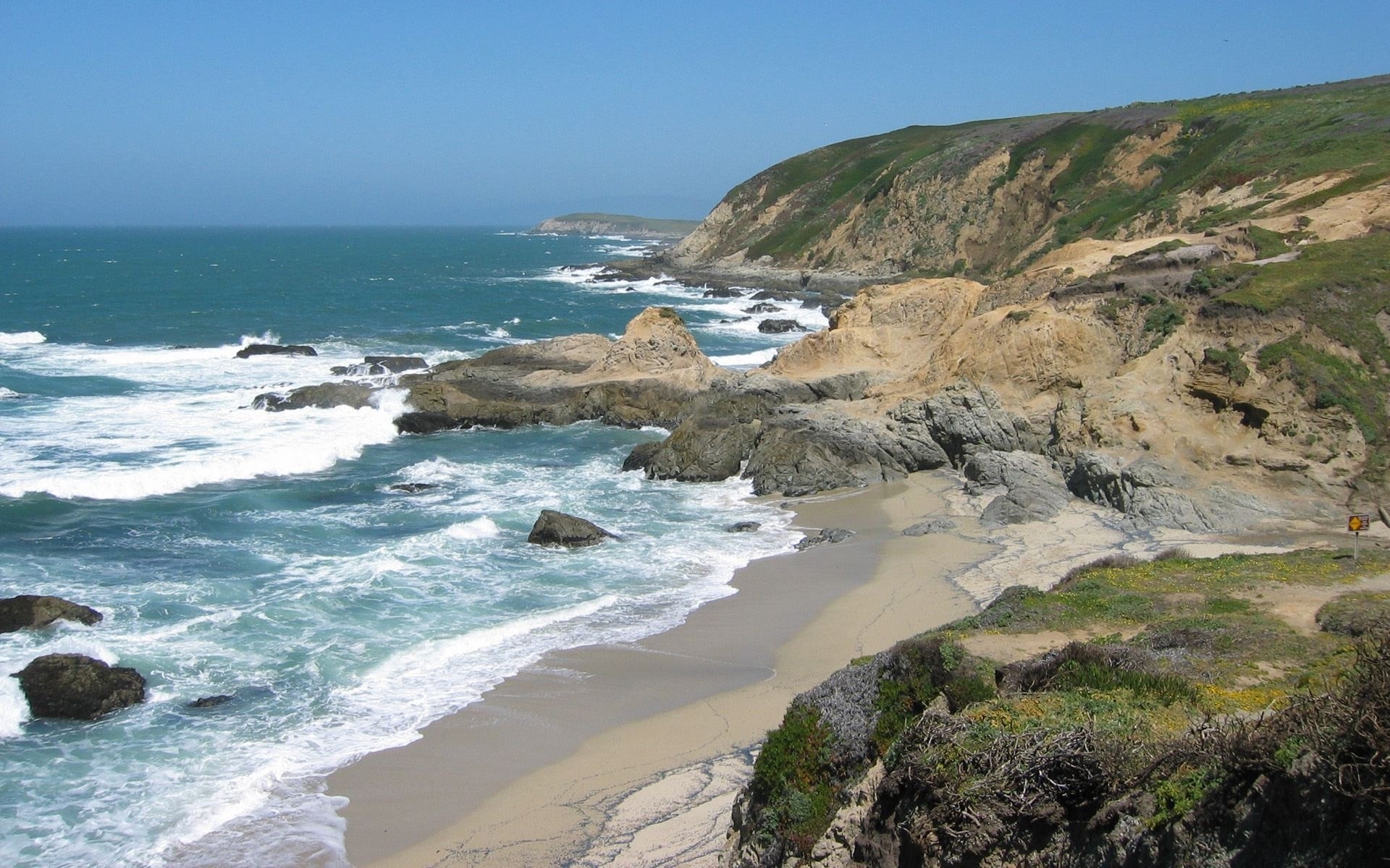 Rocky coastline with waves crashing on the shore HD Wallpaper